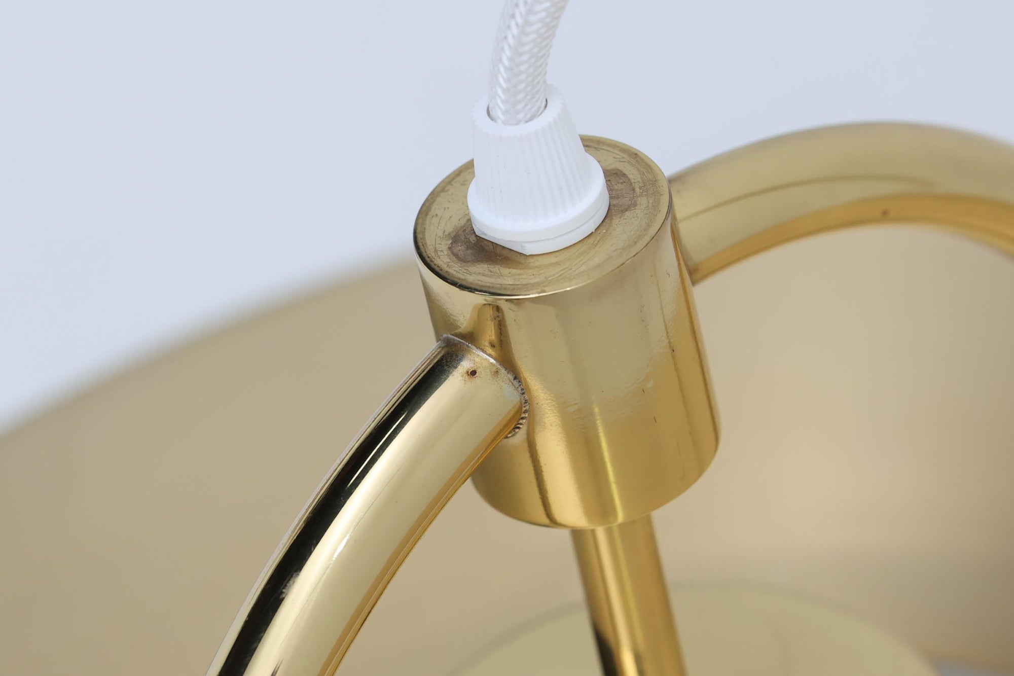 デンマークの照明ブランド、Fog &amp; morup（フォグ＆モーラップ）社によるペンダントライト「Hercules」。デザインは同社を代表するデザイナー、Jo Hammerborg（ヨー・ハーマボー）。直径41cmの存在感あるサイズに、上下を弧状に囲む真鍮製のアームが印象的な構造で、点灯時には下部のリングが光を受けて柔らかく浮かび上がります。外側はゴールドブラス、内側はホワイトで塗装されており、光の反射を美しく拡散させる仕様です。経年により一部にくすみや細かなキズが見られますが、全体としては美しい輝きを保っており、ビンテージならではの雰囲気を楽しめる一点です。E26口金のLED電球に対応し、現代の生活空間でも安心してご使用いただけます。北欧ミッドセンチュリーデザインの象徴的な一灯として、リビングやダイニングのアクセントにおすすめです。