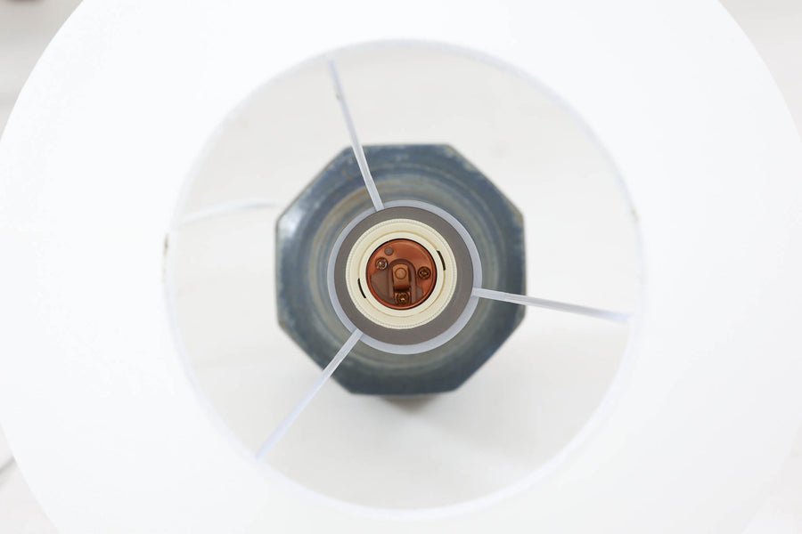 デンマーク・ボーンホルム島の名窯michael Andersen & Sonによるテーブルランプ。八角形のシャープなフォルムと、マットな質感の釉薬のコントラストが美しい一点です。落ち着いたブルーグレーのトーンがインテリアに静かなアクセントを添えてくれます。高さは約50cmとやや大きめで、程よい存在感があり、サイドボードやコンソールの上などにもおすすめです。シェードは新品のリネン製。
