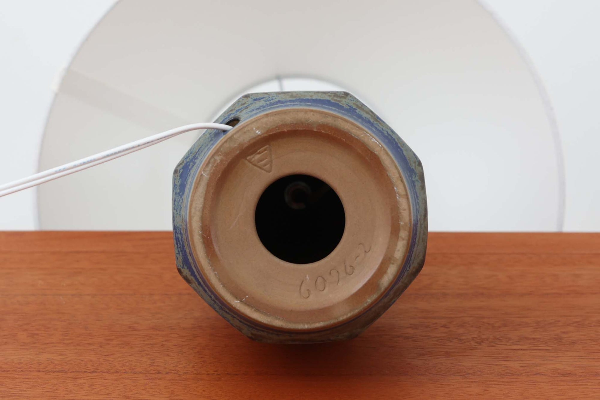 デンマーク・ボーンホルム島の名窯michael Andersen &amp; Sonによるテーブルランプ。八角形のシャープなフォルムと、マットな質感の釉薬のコントラストが美しい一点です。落ち着いたブルーグレーのトーンがインテリアに静かなアクセントを添えてくれます。高さは約50cmとやや大きめで、程よい存在感があり、サイドボードやコンソールの上などにもおすすめです。シェードは新品のリネン製。