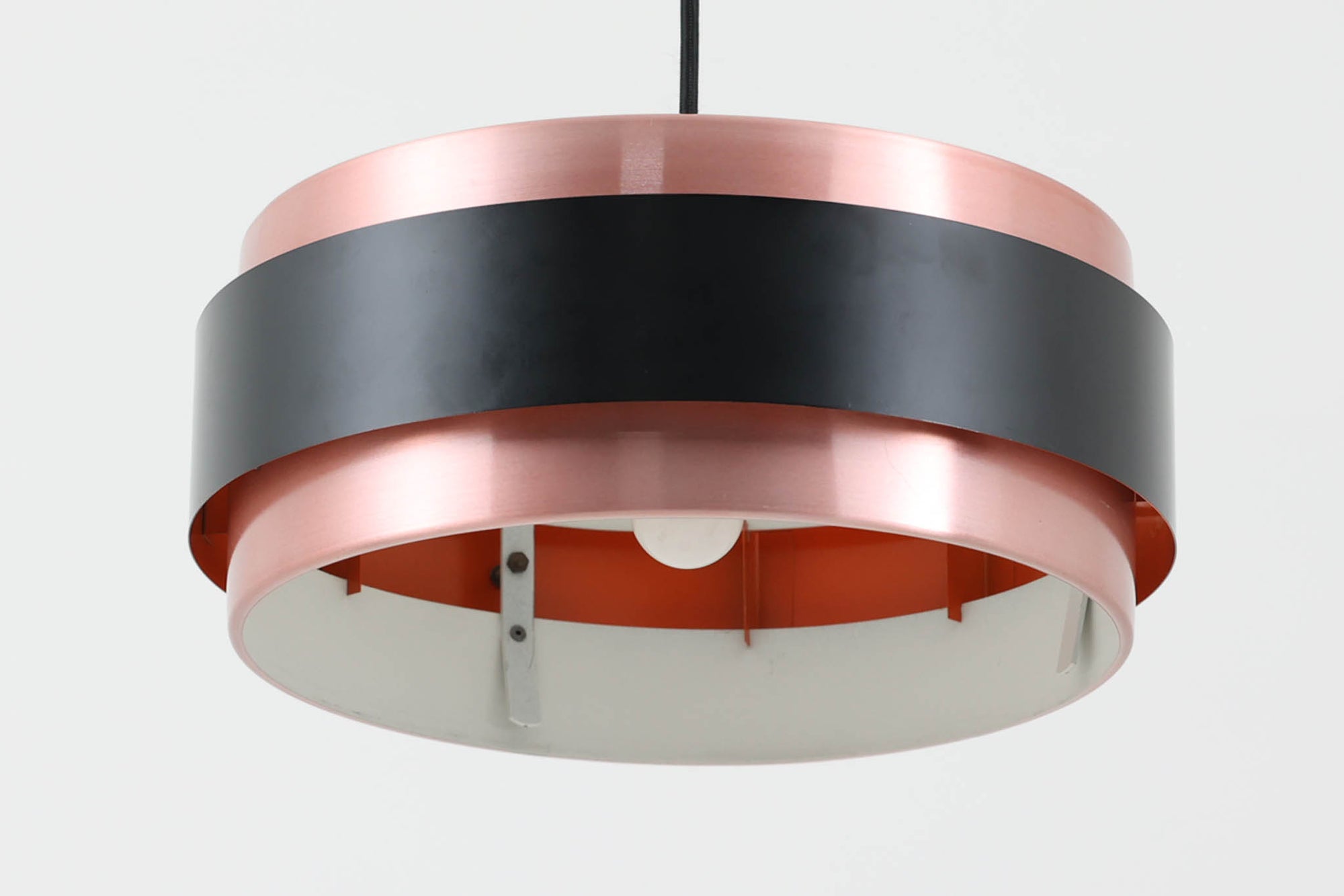 デンマークを代表する照明ブランドFog &amp; morup（フォグ＆モーラップ）社によるペンダントライト「Saturn」。デザインは同社のチーフデザイナーとして数多くの名作を生み出したJo Hammerborg（ヨー・ハーマボー）によるもの。名前の通り土星をイメージさせる円盤状のシルエットが特徴で、銅色のボディにマットブラックのバンドがアクセントとなっています。点灯時にはアクリル製のディフューザーを通して柔らかな光が広がり、上部から漏れる光が本体に陰影を与える美しい構造です。直径は34cmと空間を圧迫しないサイズ感で、ダイニングや書斎、ベッドサイドなど多用途にお使いいただけます。ボトムカバーのガラスは付属しておりませんのでご了承ください。ビンテージならではの小傷や使用感が見られますが、全体的に良好なコンディションで、モダンインテリアに映える存在感のある一灯です。