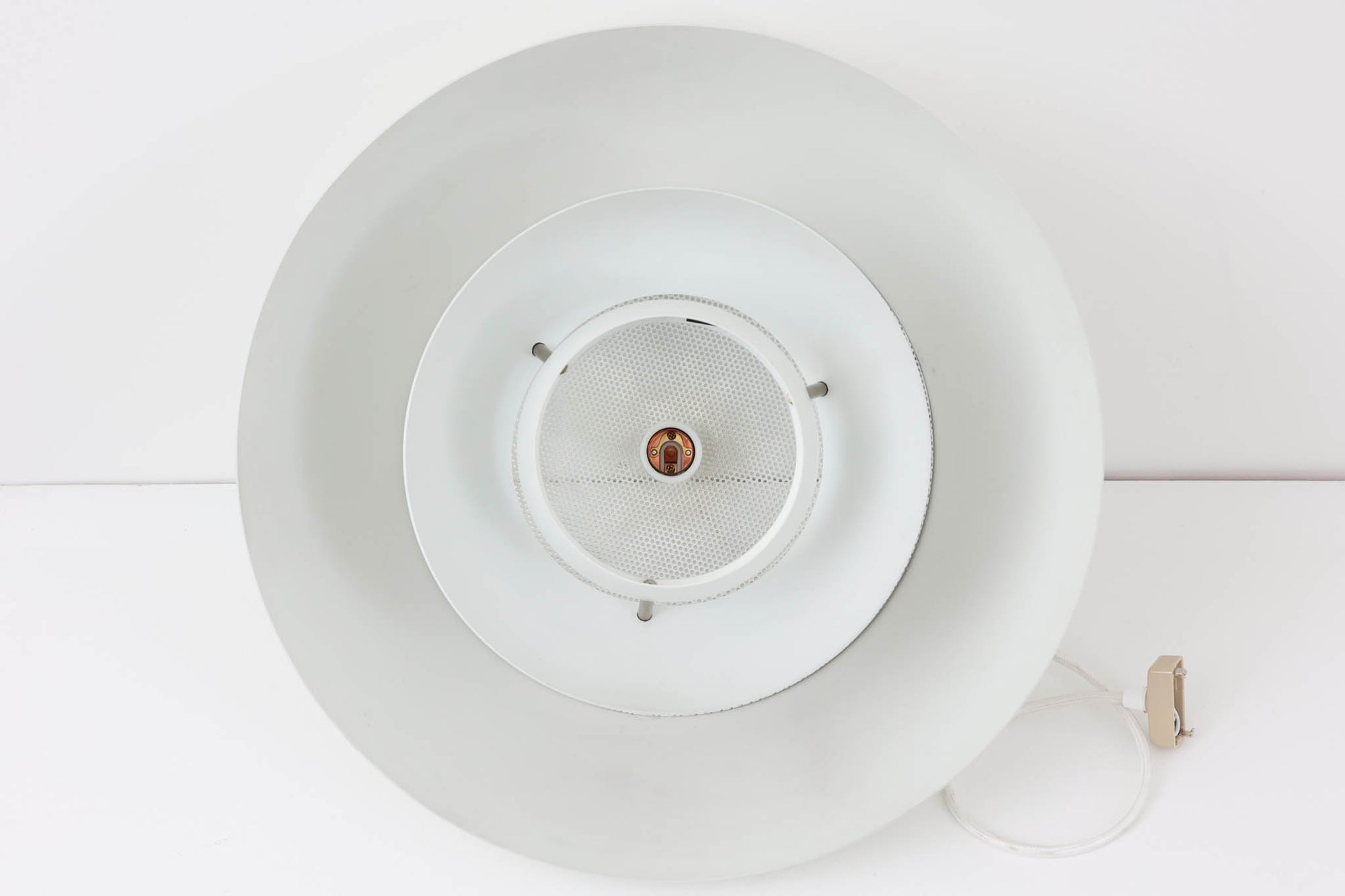 ​デンマークの照明メーカー**Nordisk Solar（ノルディック・ソーラー）**社で製造されたペンダントランプ“Safari（サファリ）”をご紹介します。​このランプは、1970年代にデンマークのデザイナー**Christian Hvidt**によってデザインされ、1981年に世界的に権威ある「iFプロダクトデザイン賞」を受賞しています。 ​デザインの特徴として、上部にはパンチングメタル製のトップディフューザーが配置されており、内部には角度の異なる2層のリフレクターを備えています。​これにより、光源が直接目に入らないグレアフリー構造となっており、柔らかな光が空間全体に穏やかに広がります。​北欧らしい機能美と造形美を兼ね備えたこの照明は、ダイニングやリビングはもちろん、商業空間のアクセントとしても最適です。一部には Hvidt &amp; molgaard の関与を示唆する情報も見受けられますが、Safariランプは公式なデザイン史料や専門的な文献では Christian Hvidt による単独デザインとして紹介されています。本体サイズは直径47cmで、存在感のあるサイズながらも上品な佇まいを持つ一品です。