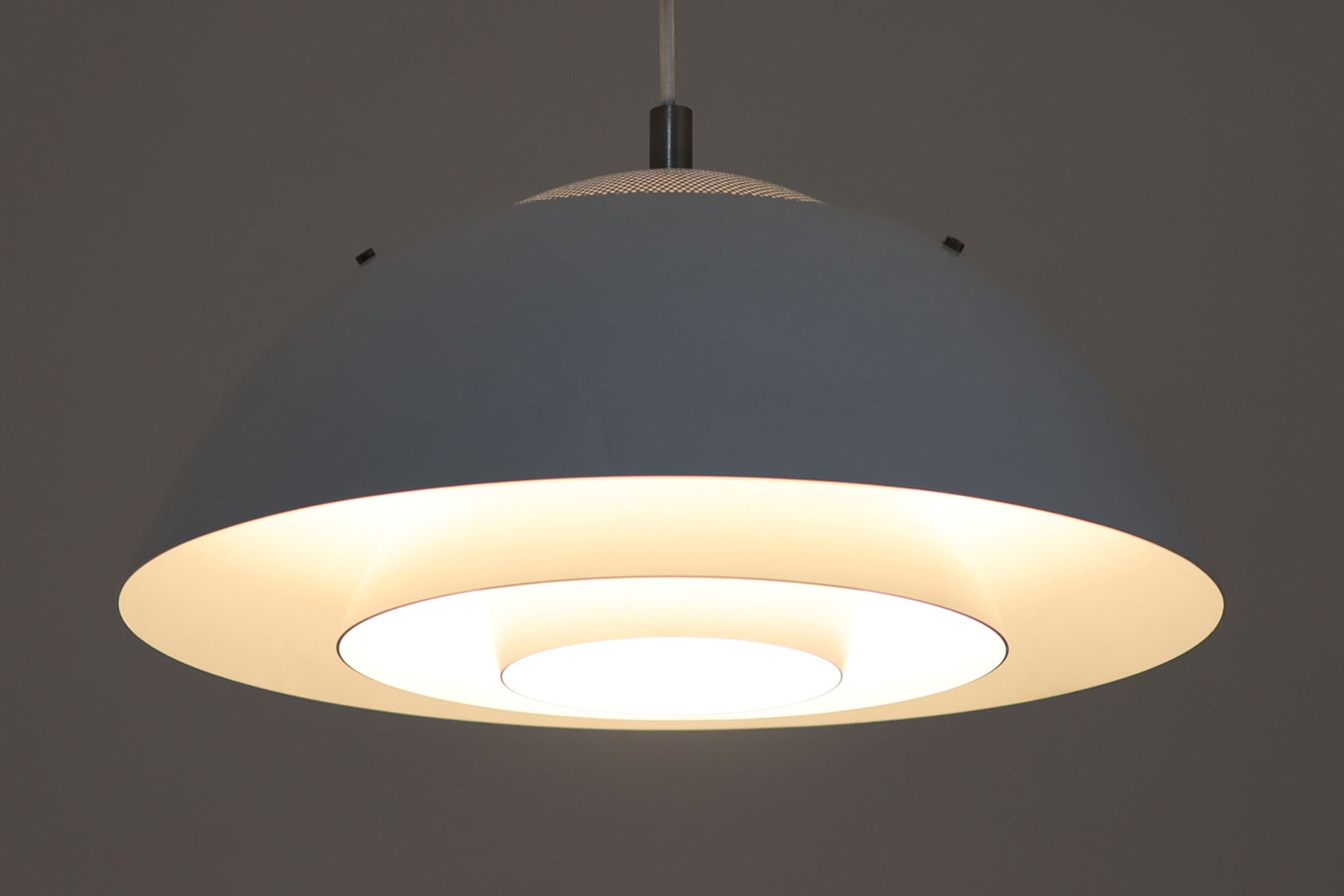 ​デンマークの照明メーカー**Nordisk Solar（ノルディック・ソーラー）**社で製造されたペンダントランプ“Safari（サファリ）”をご紹介します。​このランプは、1970年代にデンマークのデザイナー**Christian Hvidt**によってデザインされ、1981年に世界的に権威ある「iFプロダクトデザイン賞」を受賞しています。 ​デザインの特徴として、上部にはパンチングメタル製のトップディフューザーが配置されており、内部には角度の異なる2層のリフレクターを備えています。​これにより、光源が直接目に入らないグレアフリー構造となっており、柔らかな光が空間全体に穏やかに広がります。​北欧らしい機能美と造形美を兼ね備えたこの照明は、ダイニングやリビングはもちろん、商業空間のアクセントとしても最適です。一部には Hvidt &amp; molgaard の関与を示唆する情報も見受けられますが、Safariランプは公式なデザイン史料や専門的な文献では Christian Hvidt による単独デザインとして紹介されています。本体サイズは直径47cmで、存在感のあるサイズながらも上品な佇まいを持つ一品です。