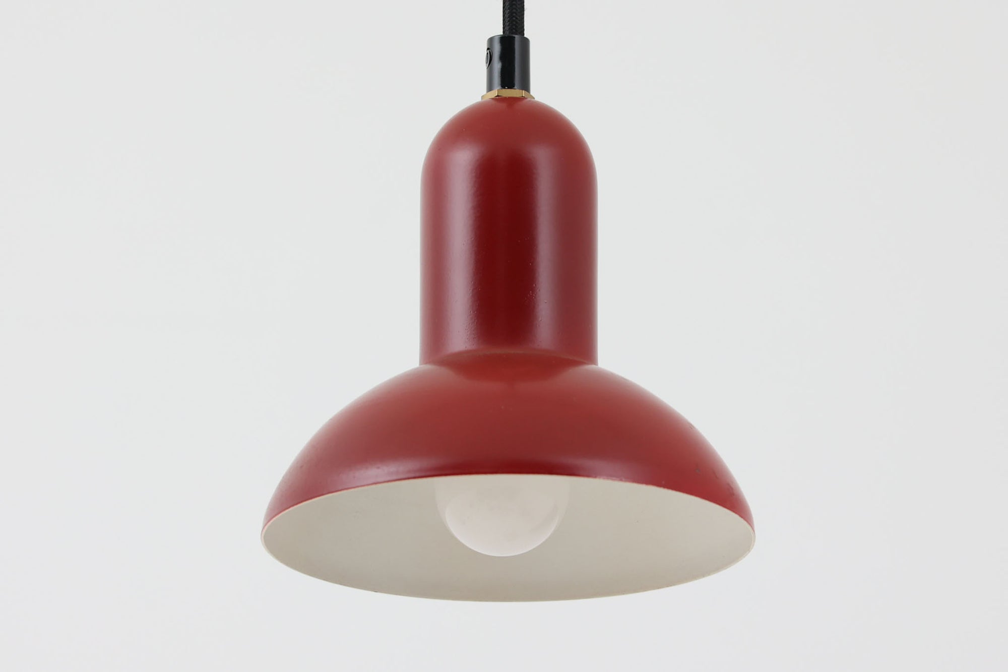 デンマークの老舗照明ブランドLYFA社による、Type 4784のビンテージペンダントライトです。丸みを帯びたチューブ状のトップから柔らかく広がるシェードへと続く滑らかなフォルムが特徴で、小ぶりながらも印象的な存在感を放ちます。直径14cmのコンパクトなサイズ感は、ダイニングやキッチンカウンター、玄関やトイレなどの小空間にも適しており、複数灯を並べても美しくまとまります。赤色の本体と、白く塗装された内側のコントラストが光を柔らかく反射させ、空間に温かみのある灯りをもたらします。シンプルでありながら北欧デザインらしい機能美が感じられる一品で、現行では手に入らない希少なビンテージアイテムとしておすすめです。