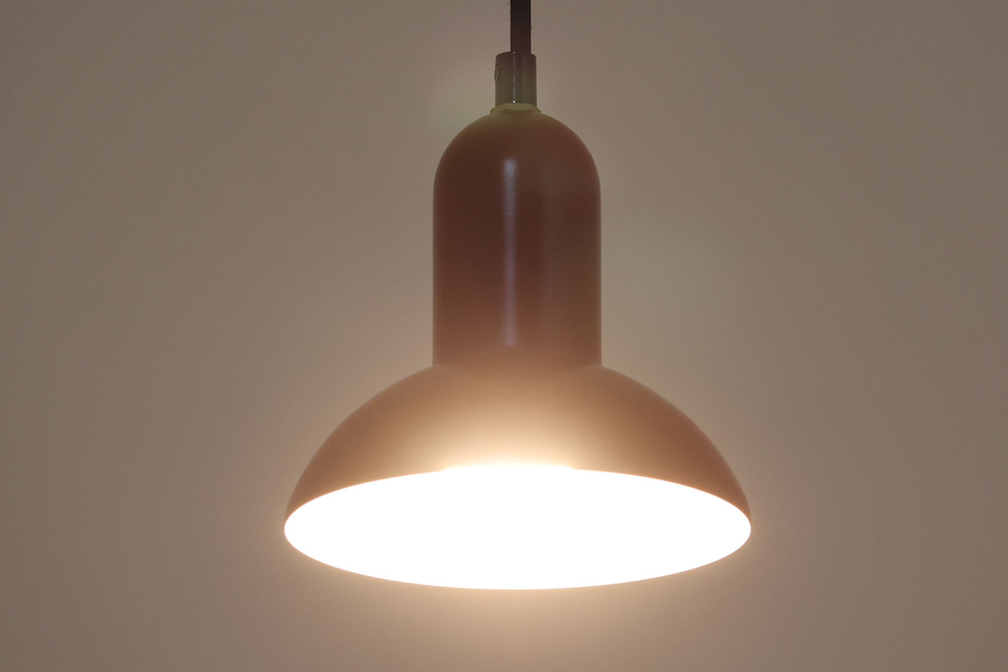 デンマークの老舗照明ブランドLYFA社による、Type 4784のビンテージペンダントライトです。丸みを帯びたチューブ状のトップから柔らかく広がるシェードへと続く滑らかなフォルムが特徴で、小ぶりながらも印象的な存在感を放ちます。直径14cmのコンパクトなサイズ感は、ダイニングやキッチンカウンター、玄関やトイレなどの小空間にも適しており、複数灯を並べても美しくまとまります。赤色の本体と、白く塗装された内側のコントラストが光を柔らかく反射させ、空間に温かみのある灯りをもたらします。シンプルでありながら北欧デザインらしい機能美が感じられる一品で、現行では手に入らない希少なビンテージアイテムとしておすすめです。