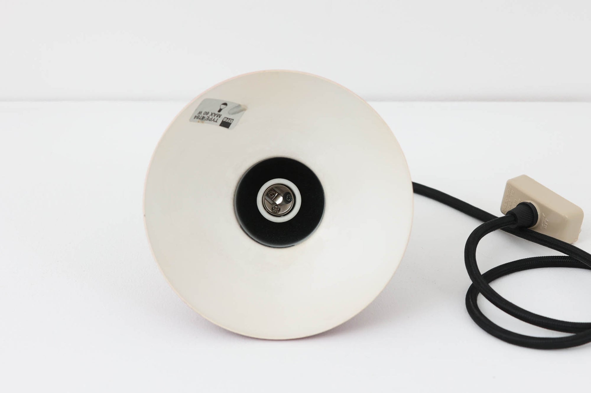 デンマークの老舗照明ブランドLYFA社による、Type 4784のビンテージペンダントライトです。丸みを帯びたチューブ状のトップから柔らかく広がるシェードへと続く滑らかなフォルムが特徴で、小ぶりながらも印象的な存在感を放ちます。直径14cmのコンパクトなサイズ感は、ダイニングやキッチンカウンター、玄関やトイレなどの小空間にも適しており、複数灯を並べても美しくまとまります。赤色の本体と、白く塗装された内側のコントラストが光を柔らかく反射させ、空間に温かみのある灯りをもたらします。シンプルでありながら北欧デザインらしい機能美が感じられる一品で、現行では手に入らない希少なビンテージアイテムとしておすすめです。