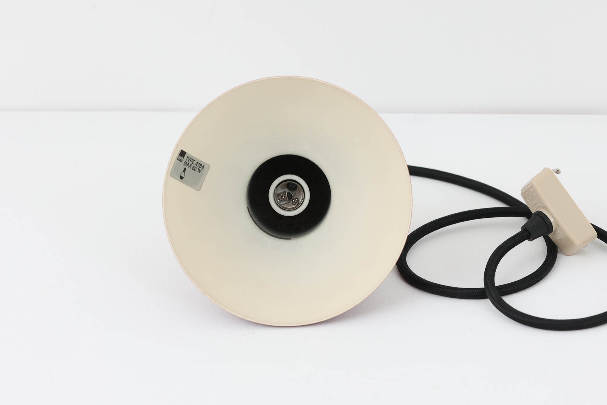 デンマークの老舗照明ブランドLYFA社による、Type 4784のビンテージペンダントライトです。丸みを帯びたチューブ状のトップから柔らかく広がるシェードへと続く滑らかなフォルムが特徴で、小ぶりながらも印象的な存在感を放ちます。直径14cmのコンパクトなサイズ感は、ダイニングやキッチンカウンター、玄関やトイレなどの小空間にも適しており、複数灯を並べても美しくまとまります。赤色の本体と、白く塗装された内側のコントラストが光を柔らかく反射させ、空間に温かみのある灯りをもたらします。シンプルでありながら北欧デザインらしい機能美が感じられる一品で、現行では手に入らない希少なビンテージアイテムとしておすすめです。