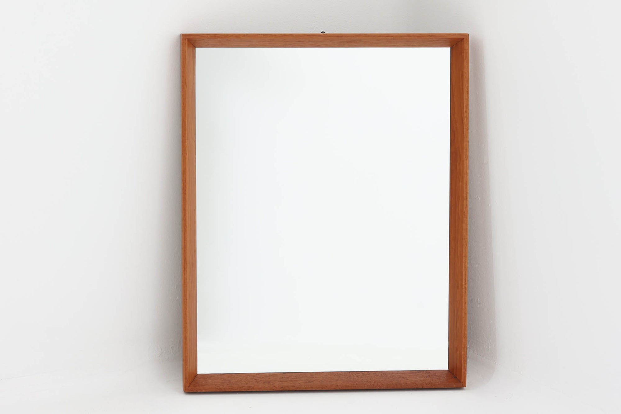 美しい木目が際立つチーク材で縁取られた壁掛け・立て掛け両用のミラーです。フレームの仕上げは細部にまで丁寧な加工が施され、シンプルながらも北欧ビンテージ家具特有の温もりと品格を感じさせるデザインに仕上がっています。高さ45cmのコンパクトなサイズ感は、玄関や洗面所、リビングなどさまざまな空間で取り入れやすく、空間に奥行きと明るさを加えるアイテムとして活躍します。日常使いはもちろん、装飾性も高くインテリアのアクセントとしてもおすすめです。