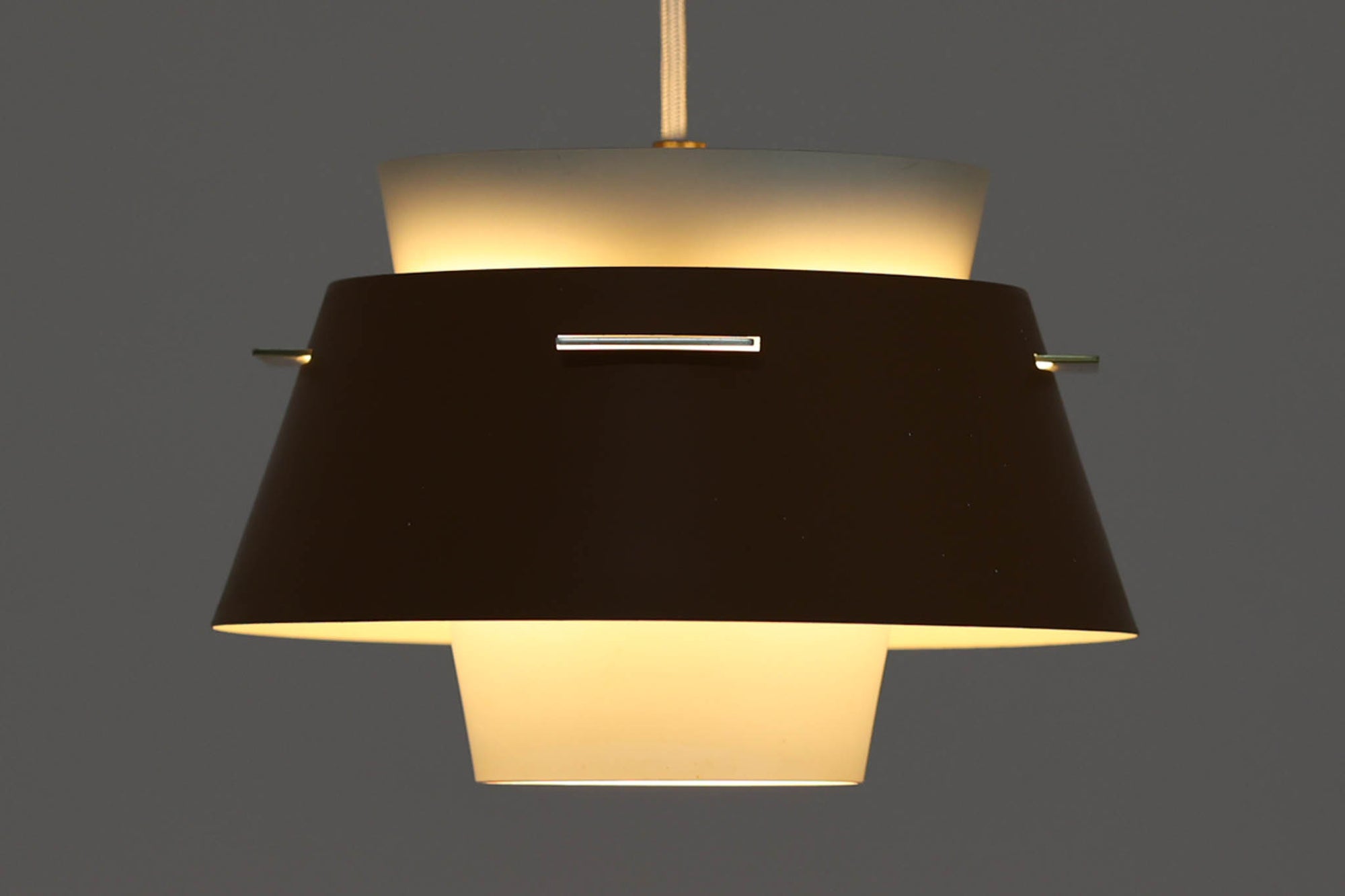 デンマークの老舗照明メーカーLYFA社より、Birger Schmidtデザインのビンテージペンダントライトです。キャメルとホワイトのコントラストが美しく、洗練されたシンプルさの中にも温かみのあるデザインが特徴です。メタル製シェードは2層構造になっており、柔らかく穏やかな光が上下に広がり、空間を優しく照らします。点灯時には、内側のホワイトシェードが温かな光を演出し、北欧ならではの心地よさを感じさせてくれます。サイズは直径24cm、高さ16cmとコンパクトで、リビングやダイニング、ベッドルームなど幅広いシーンでお使いいただけます。ヴィンテージならではの趣あるデザインと確かな品質が魅力の逸品です。