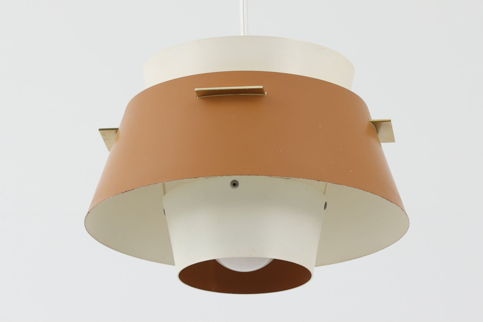 デンマークの老舗照明メーカーLYFA社より、Birger Schmidtデザインのビンテージペンダントライトです。キャメルとホワイトのコントラストが美しく、洗練されたシンプルさの中にも温かみのあるデザインが特徴です。メタル製シェードは2層構造になっており、柔らかく穏やかな光が上下に広がり、空間を優しく照らします。点灯時には、内側のホワイトシェードが温かな光を演出し、北欧ならではの心地よさを感じさせてくれます。サイズは直径24cm、高さ16cmとコンパクトで、リビングやダイニング、ベッドルームなど幅広いシーンでお使いいただけます。ヴィンテージならではの趣あるデザインと確かな品質が魅力の逸品です。