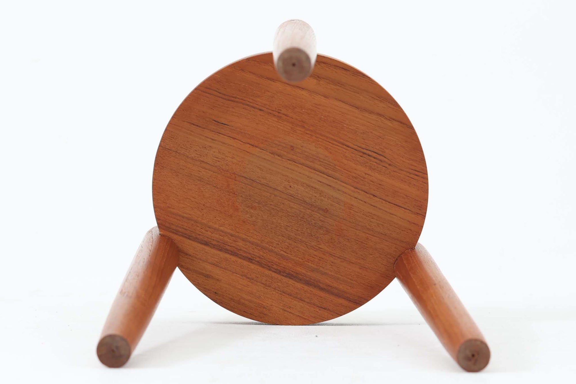 デンマーク製のビンテージ3本脚サイドテーブルです。天板・脚部ともにチーク無垢材を使用しており、木の質感を存分に楽しめる一品です。円形の天板に3本の丸脚を配したシンプルなデザインながら、脚の先端が天板を貫通して突き出した構造がアクセントとなり、クラフト感のある佇まいを演出しています。花台やソファ横のテーブルとしてなど、空間のポイントになる小家具としておすすめです。幅24cm×奥行24.5cmとコンパクトなサイズ感で、日本の住空間にも取り入れやすいアイテムです。