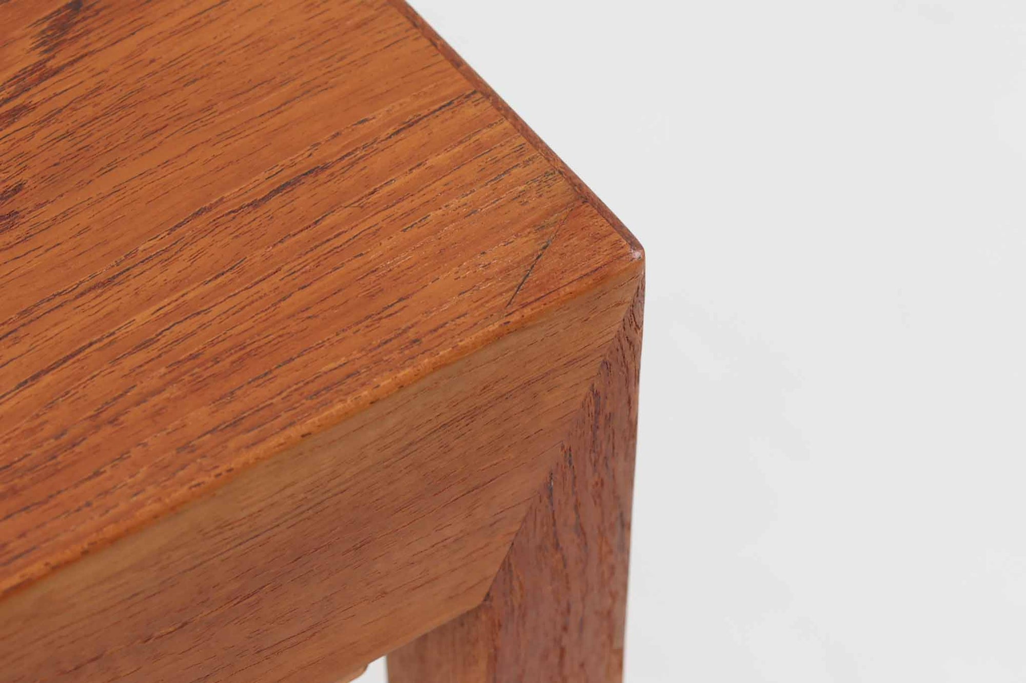 デンマークの名デザイナーSeverin Hansen Jr.が手掛け、Haslev社によって製造された北欧ビンテージのソーイングテーブルです。素材には温かみのあるチーク材が使用され、シャープな接合部とすっきりとしたテーパードレッグが洗練された佇まいを演出しています。特徴的な籐のバスケットは糸や道具類をたっぷりと収納でき、天板下のスライドトレイには仕切りがあり細かな道具の整理にも便利です。バスケットを支える木製レールの一部に欠けがありますが、使用には支障ありません。実用性と美しさを兼ね備えた一台で、裁縫道具の収納にはもちろん、サイドテーブルとしてもおすすめです。