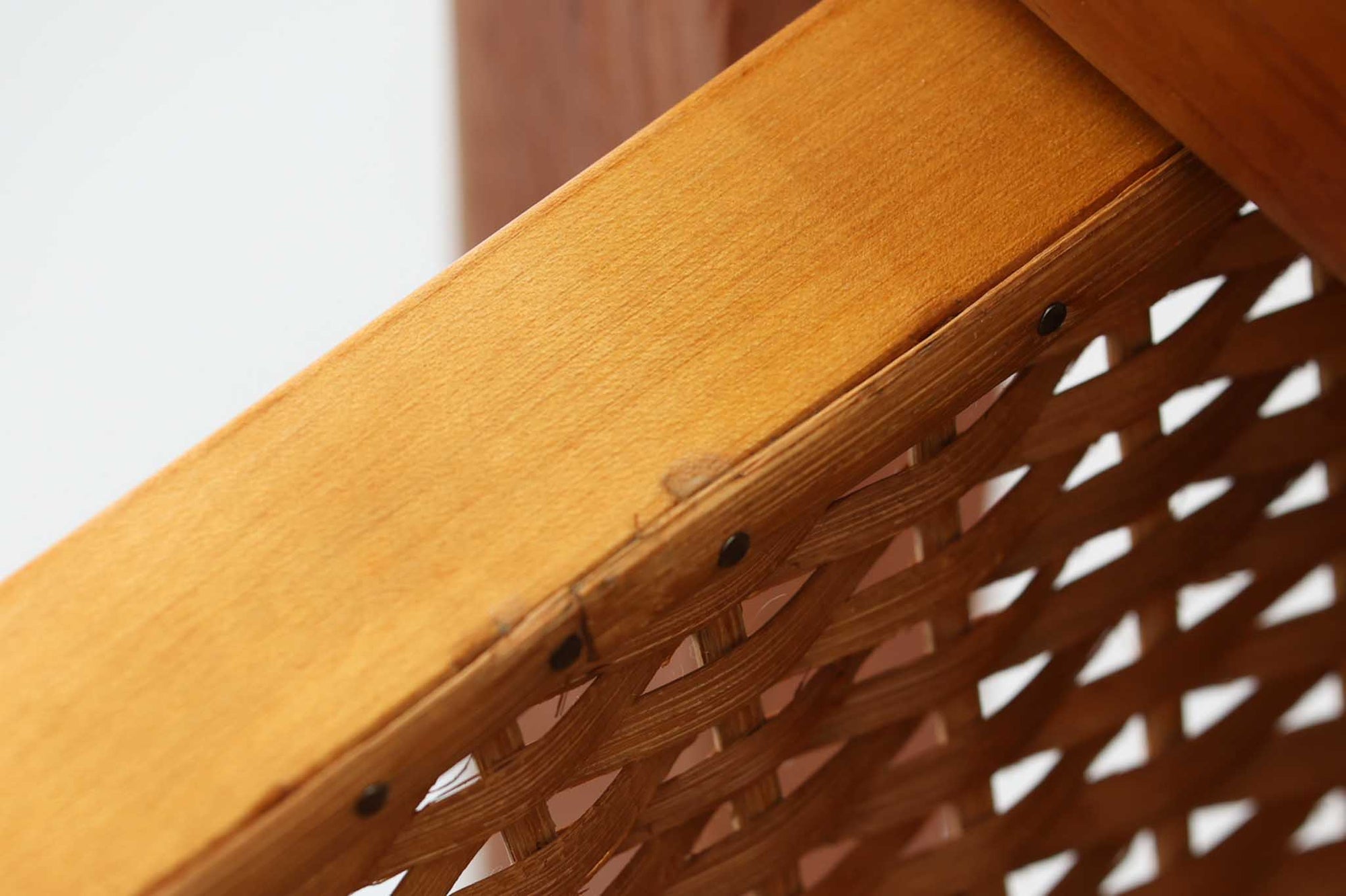 デンマークの名デザイナーSeverin Hansen Jr.が手掛け、Haslev社によって製造された北欧ビンテージのソーイングテーブルです。素材には温かみのあるチーク材が使用され、シャープな接合部とすっきりとしたテーパードレッグが洗練された佇まいを演出しています。特徴的な籐のバスケットは糸や道具類をたっぷりと収納でき、天板下のスライドトレイには仕切りがあり細かな道具の整理にも便利です。バスケットを支える木製レールの一部に欠けがありますが、使用には支障ありません。実用性と美しさを兼ね備えた一台で、裁縫道具の収納にはもちろん、サイドテーブルとしてもおすすめです。