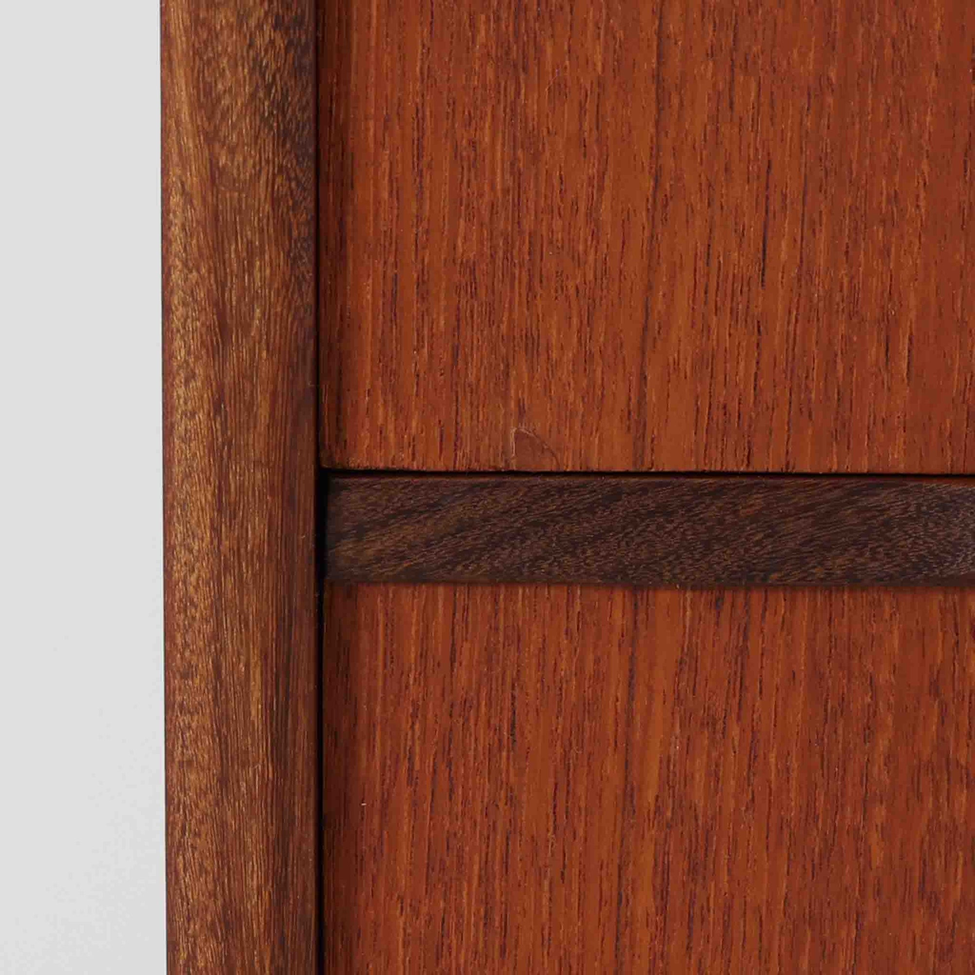 チーク材の温もりが魅力のこちらのディスプレイシェルフは、引き出し収納と棚が一体となった北欧ビンテージらしい実用性と美しさを兼ね備えた一台で、下段には鍵付きの3杯引き出し、上段には棚が3段設けられており、書斎やリビングの収納兼飾り棚としてはもちろん、店舗什器としても活躍します。細身の丸脚が全体に軽やかな印象を与え、チーク材特有の深みのある色合いと経年による艶が上質な雰囲気を醸し出しています。