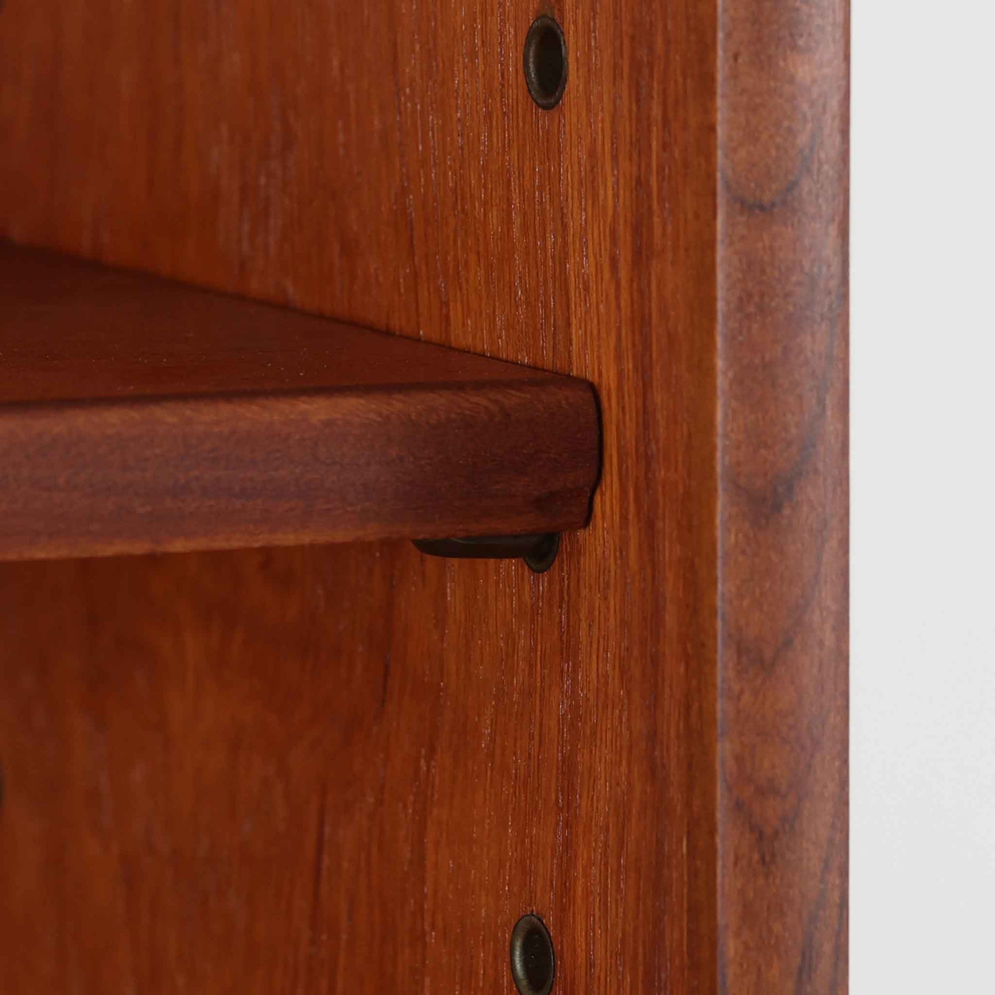 チーク材の温もりが魅力のこちらのディスプレイシェルフは、引き出し収納と棚が一体となった北欧ビンテージらしい実用性と美しさを兼ね備えた一台で、下段には鍵付きの3杯引き出し、上段には棚が3段設けられており、書斎やリビングの収納兼飾り棚としてはもちろん、店舗什器としても活躍します。細身の丸脚が全体に軽やかな印象を与え、チーク材特有の深みのある色合いと経年による艶が上質な雰囲気を醸し出しています。