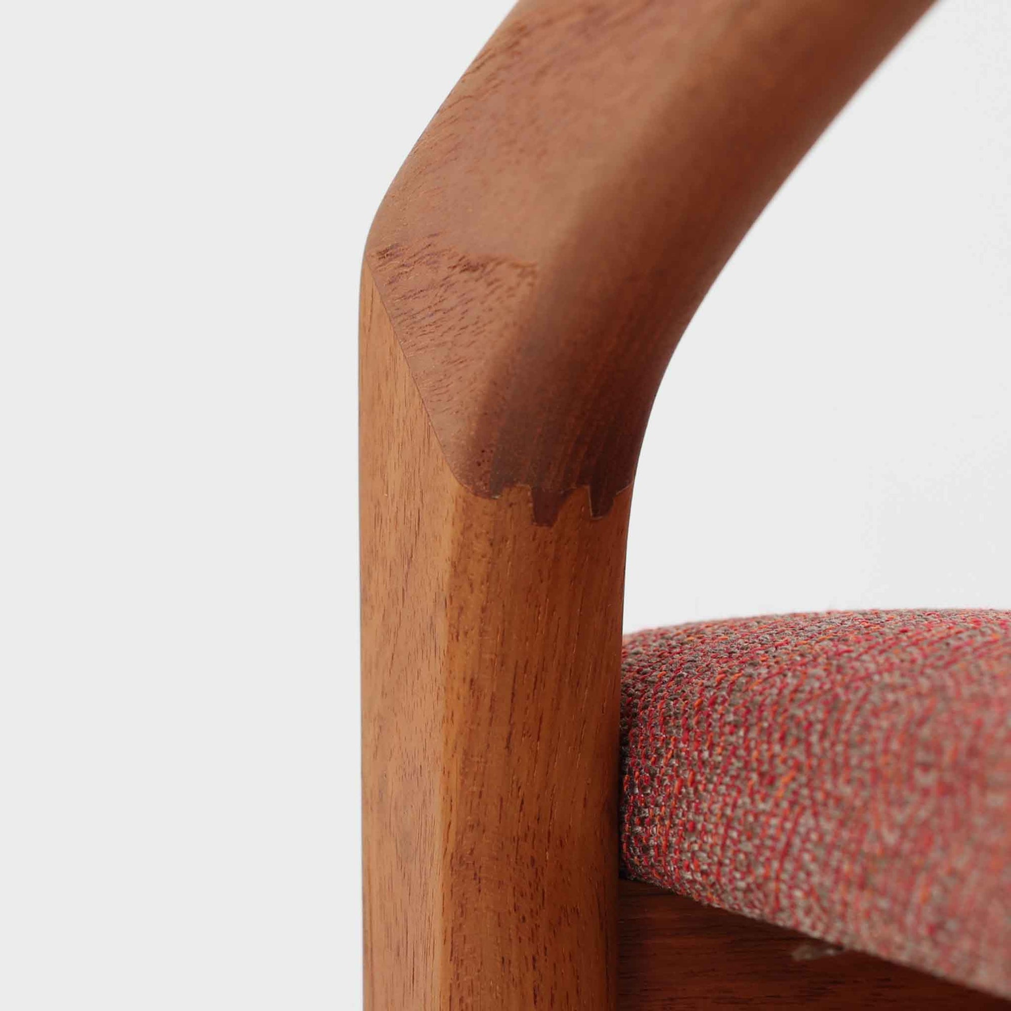 Henning Kjaernulfが手がけたアームチェア「Model 23」は、Korup Stolefabrik社によって製造された北欧ビンテージ家具です。フレームには上質なチーク材が用いられ、厚みのある前脚から背面へと繋がる彫刻的な曲線が印象的で、クラフトマンシップが光る仕上がりとなっています。アーム部分のカットや立体的な背もたれも美しく、彫刻家具のような存在感があります。張地にはレッド系の網代文様のファブリックを採用し、空間に鮮やかなアクセントを添えます。ダイニングはもちろん、書斎やリビングにもおすすめの一脚です。