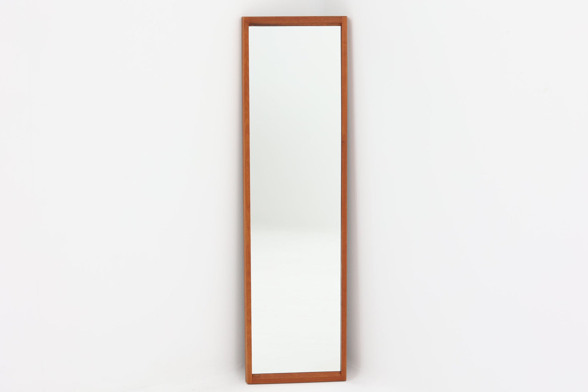 デンマークの家具ブランドAksel Kjersgaard（アクセル・キアスゴー）製、Kai Kristiansen（カイ・クリスチャンセン）デザインのビンテージミラーです。無垢チーク材による繊細でシャープなフレームが特徴で、丁寧な仕口や木目の美しさから高い品質が伺えます。幅29cmとスリムでありながら、高さ104cmと全身を映すのに十分なサイズ感があり、玄関や寝室など限られたスペースにもおすすめの一枚です。背面には「Aksel Kjersgaard ODDER」の焼印も確認できます。ビンテージ品のため経年によるわずかな使用感は見られますが、全体としては良好なコンディションを保っています。