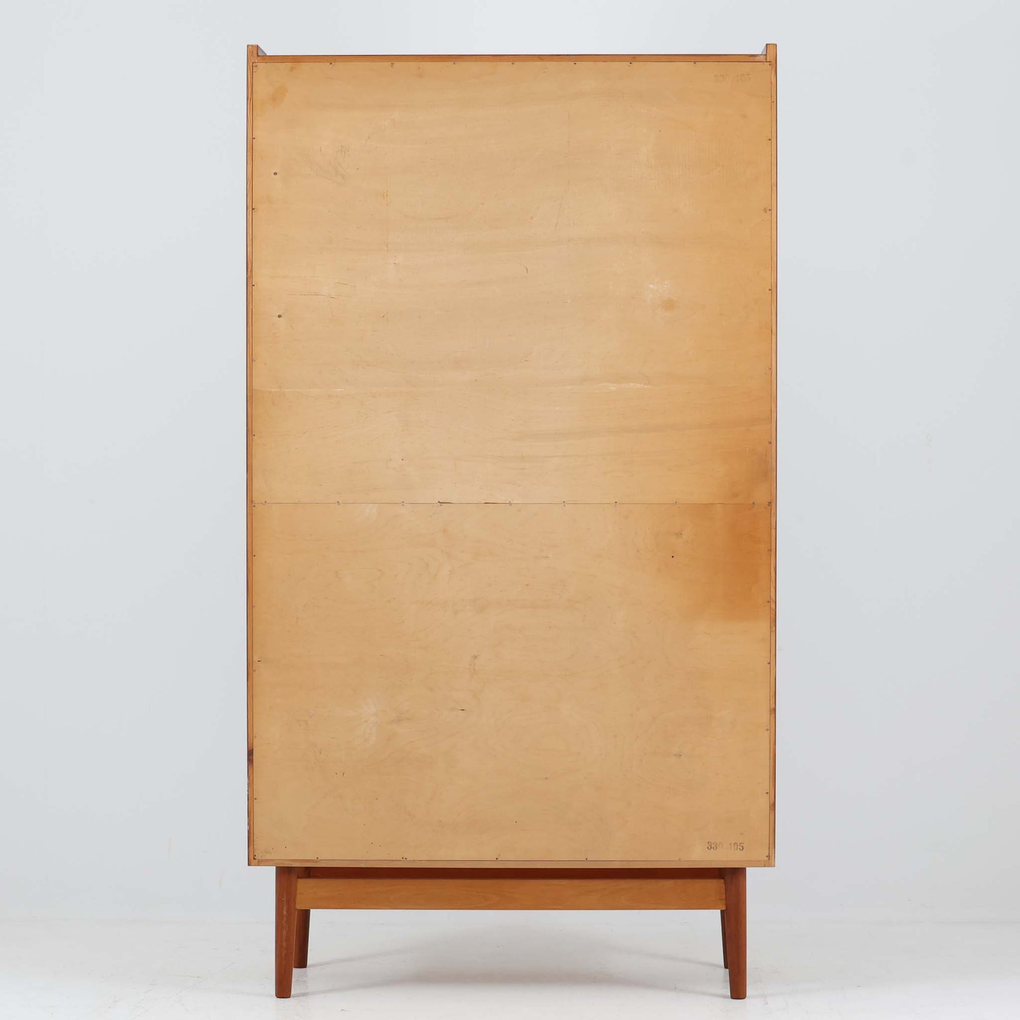 Johannes Sorth（ヨハネス・ソース）によるNexo Mobelfabrik社製のチーク材ディスプレイシェルフです。幅100cmと程よいサイズ感で、上段の棚は高さのある書籍やオブジェを飾るのに適しており、中央の蛇腹扉の内側には小引き出しや仕切りが備わり、細かな収納にも対応します。下段の3杯の引き出しは収納力に優れ、衣類や書類の整理に便利です。直線的なフォルムに温かみのあるチーク材の木目が映え、経年の艶が深みを増したビンテージらしい風合いを楽しめます。機能性と美観を兼ね備えた北欧家具の魅力が詰まった一台です。