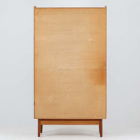 Johannes Sorth（ヨハネス・ソース）によるNexo Mobelfabrik社製のチーク材ディスプレイシェルフです。幅100cmと程よいサイズ感で、上段の棚は高さのある書籍やオブジェを飾るのに適しており、中央の蛇腹扉の内側には小引き出しや仕切りが備わり、細かな収納にも対応します。下段の3杯の引き出しは収納力に優れ、衣類や書類の整理に便利です。直線的なフォルムに温かみのあるチーク材の木目が映え、経年の艶が深みを増したビンテージらしい風合いを楽しめます。機能性と美観を兼ね備えた北欧家具の魅力が詰まった一台です。