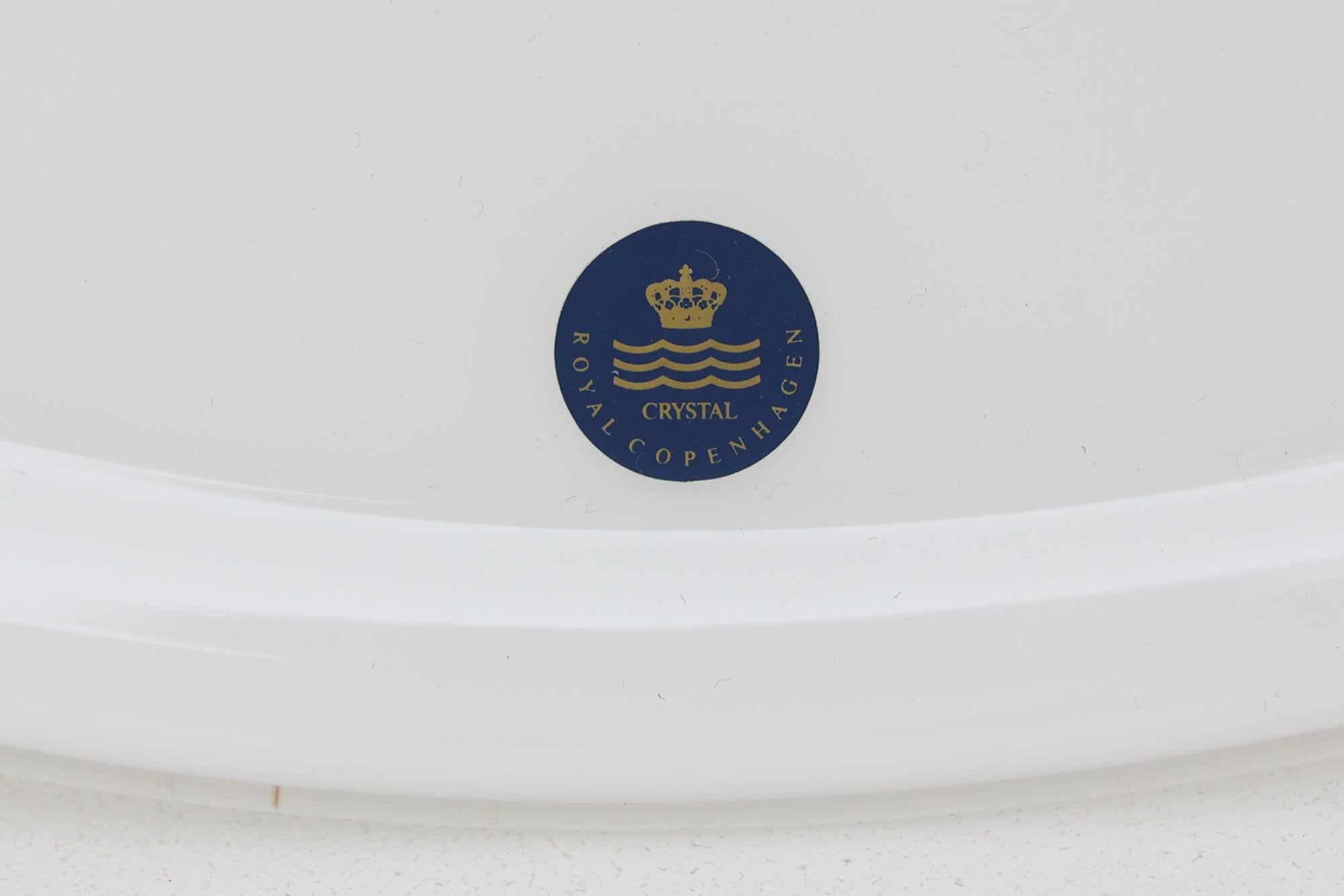 デンマークの名窯、Royal Copenhagen（ロイヤルコペンハーゲン）によるビンテージペンダントライト「Opus」。直径44cmのガラスシェードは、乳白色の滑らかな質感と優美な曲線を持ち、点灯時には柔らかな光をふんわりと拡散します。シェードの中央部にさりげない段差を設けたデザインは、シンプルながらも立体感があり、空間に洗練されたアクセントを加えます。金属パーツにはやや経年の使用感が見られますが、シェード自体は非常に良好な状態で、ガラスの透明感と清潔感を十分に感じられます。ダイニングやリビング、吹き抜けの空間など、幅広いインテリアにマッチし、北欧モダンな空間演出にぴったりの一灯です。