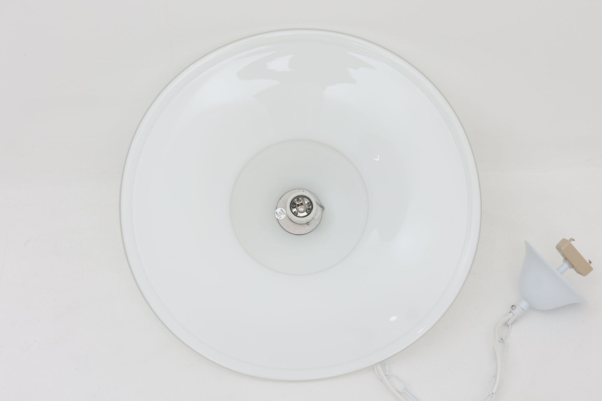 デンマークの名窯、Royal Copenhagen（ロイヤルコペンハーゲン）によるビンテージペンダントライト「Opus」。直径44cmのガラスシェードは、乳白色の滑らかな質感と優美な曲線を持ち、点灯時には柔らかな光をふんわりと拡散します。シェードの中央部にさりげない段差を設けたデザインは、シンプルながらも立体感があり、空間に洗練されたアクセントを加えます。金属パーツにはやや経年の使用感が見られますが、シェード自体は非常に良好な状態で、ガラスの透明感と清潔感を十分に感じられます。ダイニングやリビング、吹き抜けの空間など、幅広いインテリアにマッチし、北欧モダンな空間演出にぴったりの一灯です。