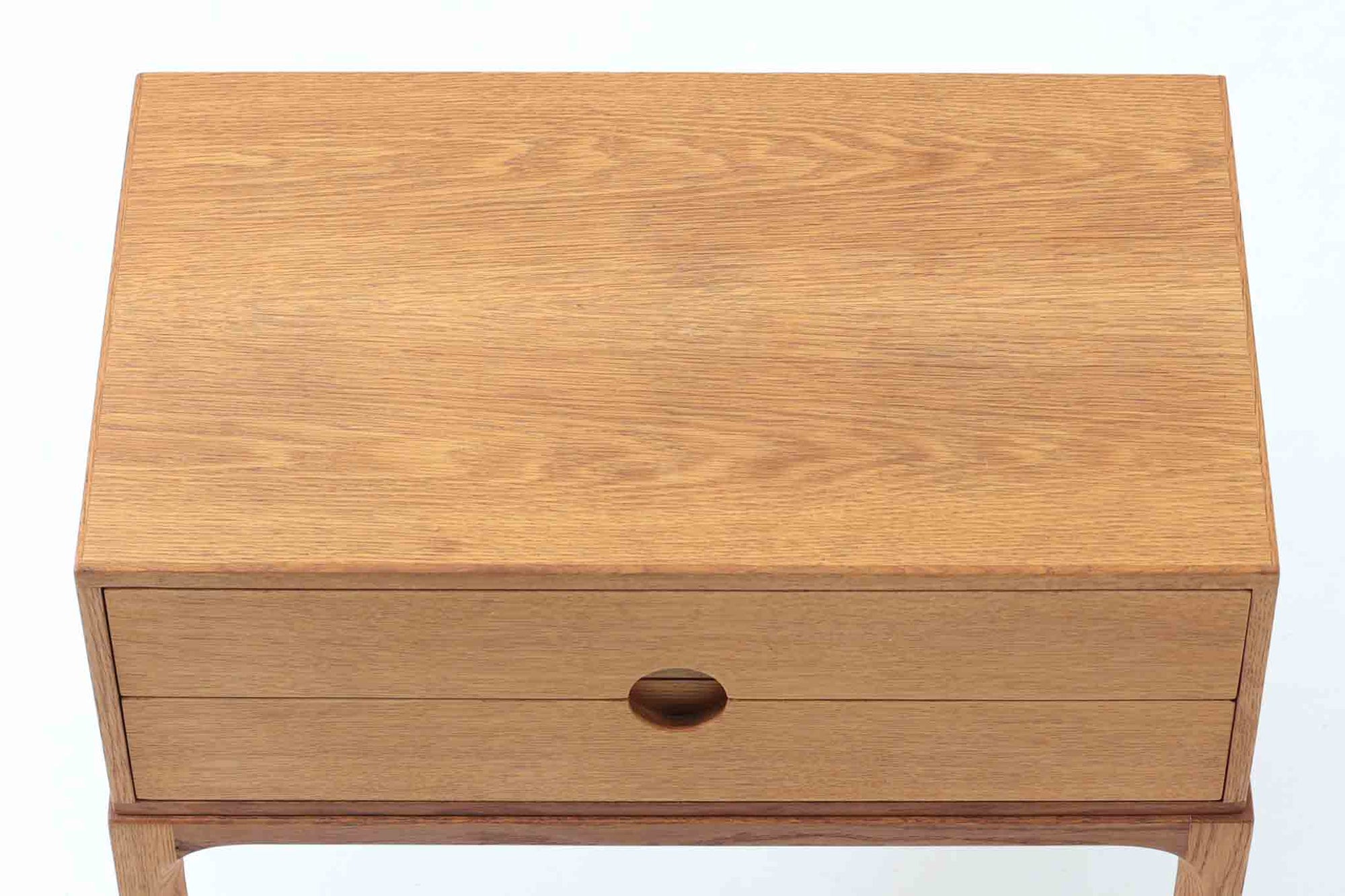 デンマークの巨匠Kai Kristiansen（カイ・クリスチャンセン）によってデザインされ、Aksel Kjersgaard（アクセル・ケアスゴー）社が製造したヴィンテージチェスト「No.384」です。素材には上質なオーク材が使用され、ナチュラルな木目とあたたかみのある色合いが魅力です。引き出しは円形のくり抜き取っ手がアクセントとなり、すっきりとした佇まいの中に北欧らしい機能美が感じられます。脚部には曲線を取り入れたデザインが施され、細部にまでこだわりが光る一台。ベッドサイドやリビング、玄関などさまざまなシーンで活躍します。裏面には「AKSEL KJERSGAARD ODDER」「mADE IN DENmARK」およびモデルナンバー「384」の刻印あり。シンプルでありながら存在感のある、北欧ヴィンテージの逸品です。