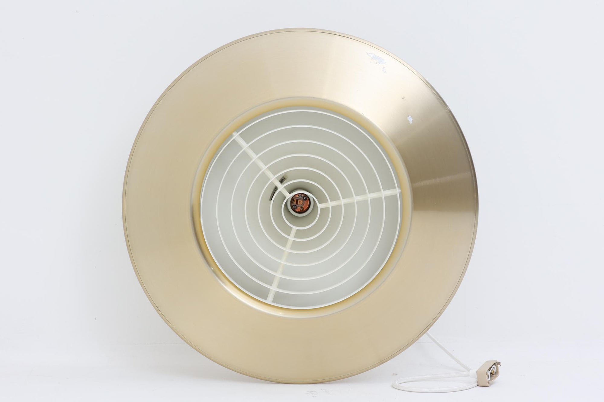 デンマークの照明メーカーLyfa社による、デザイナーEjnar B. mielby（アイナー・B・ミェルビー）が手がけた「Kuli（クーリ）」ペンダントライト。特徴的なホーン型のフォルムと、美しく仕上げられた真鍮カラーのシェードが印象的なビンテージ照明です。直径49cmと存在感のあるサイズ感で、ダイニングテーブルの上などにおすすめです。下面にはグリッド状のルーバーが備わっており、光源を柔らかく拡散しつつ眩しさを軽減する構造となっています。ソケット部分はE26口金、コードは引っ掛けシーリング仕様で、設置も簡単です。経年に伴う小傷や塗装剥がれが一部見られますが、全体としてはビンテージらしい雰囲気を保っています。空間にミッドセンチュリーのエッセンスを加える一品としておすすめです。