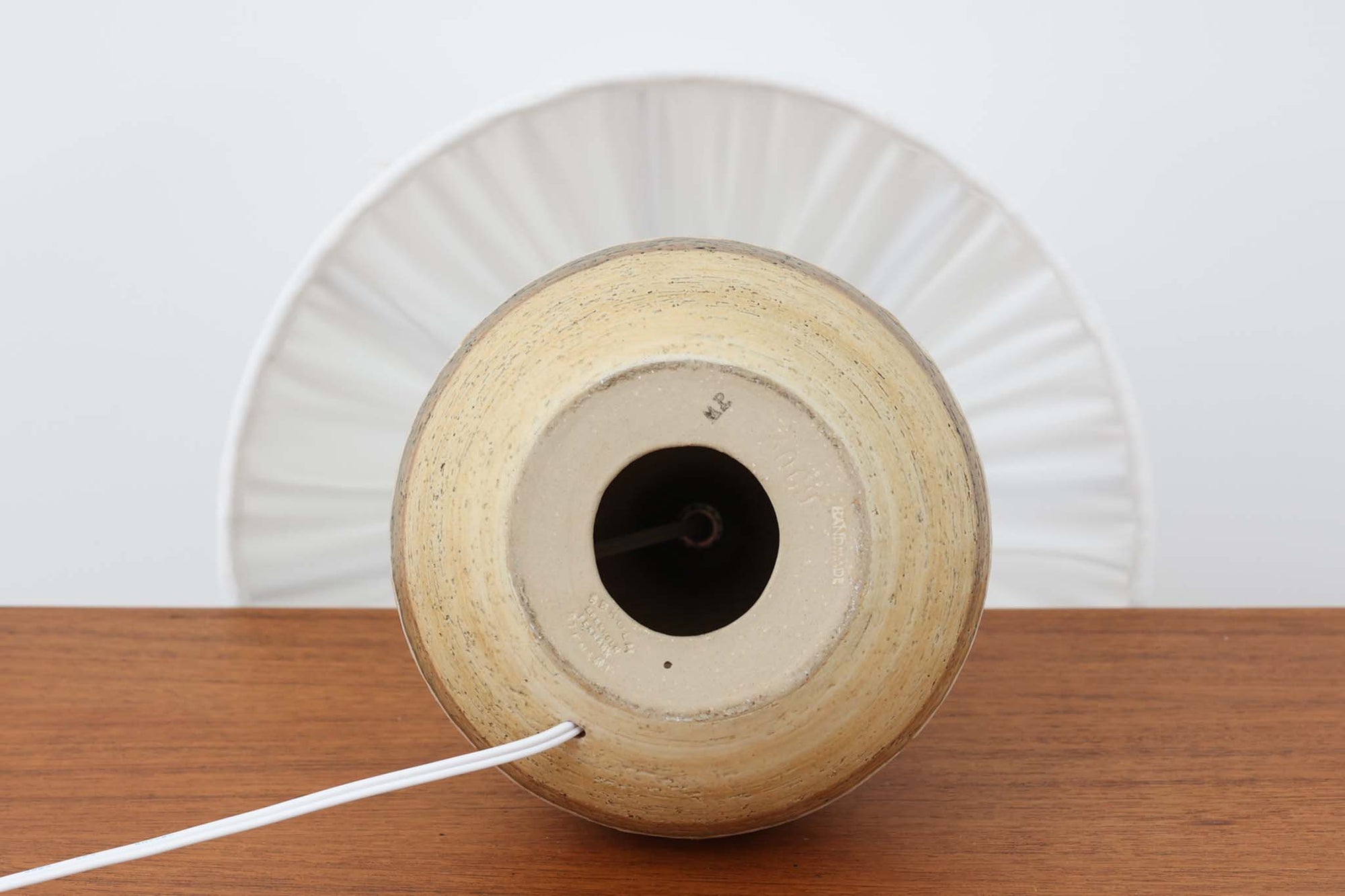 デンマーク・ボーンホルム島の名窯 SOHOLM（スーホルム）によるヴィンテージのテーブルランプです。ふっくらとしたボディに施された幾何学模様が印象的で、素朴であたたかみのある釉薬の風合いが魅力。北欧らしいナチュラルな空気感を空間に添えてくれます。高さは約48cmとやや大きめで、しっかりとした存在感がありながらも落ち着いた佇まいです。シェードは新品のリネン製に交換済み。やさしい光がファブリック越しにふんわりと広がり、ベッドサイドやリビングのアクセントにぴったりです。北欧陶器ならではの土の質感と落ち着いた色彩をお楽しみください。