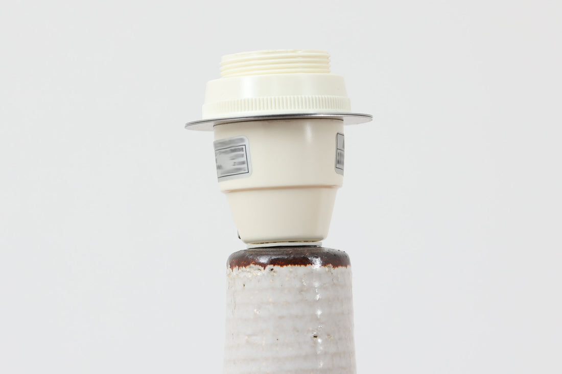 デンマーク・ボーンホルム島の陶器メーカーSoholm（スーホルム）によるヴィンテージテーブルランプ。手仕事の温もりを感じる有機的なフォルムに、抽象的で力強い絵柄が施されています。グリーンとブルーのアクセントが印象的で、陶肌の素朴な質感とも美しく調和しています。シェードは新品のリネン製。北欧らしい落ち着いた存在感があり、空間にやさしい灯りと彩りを添えてくれます。