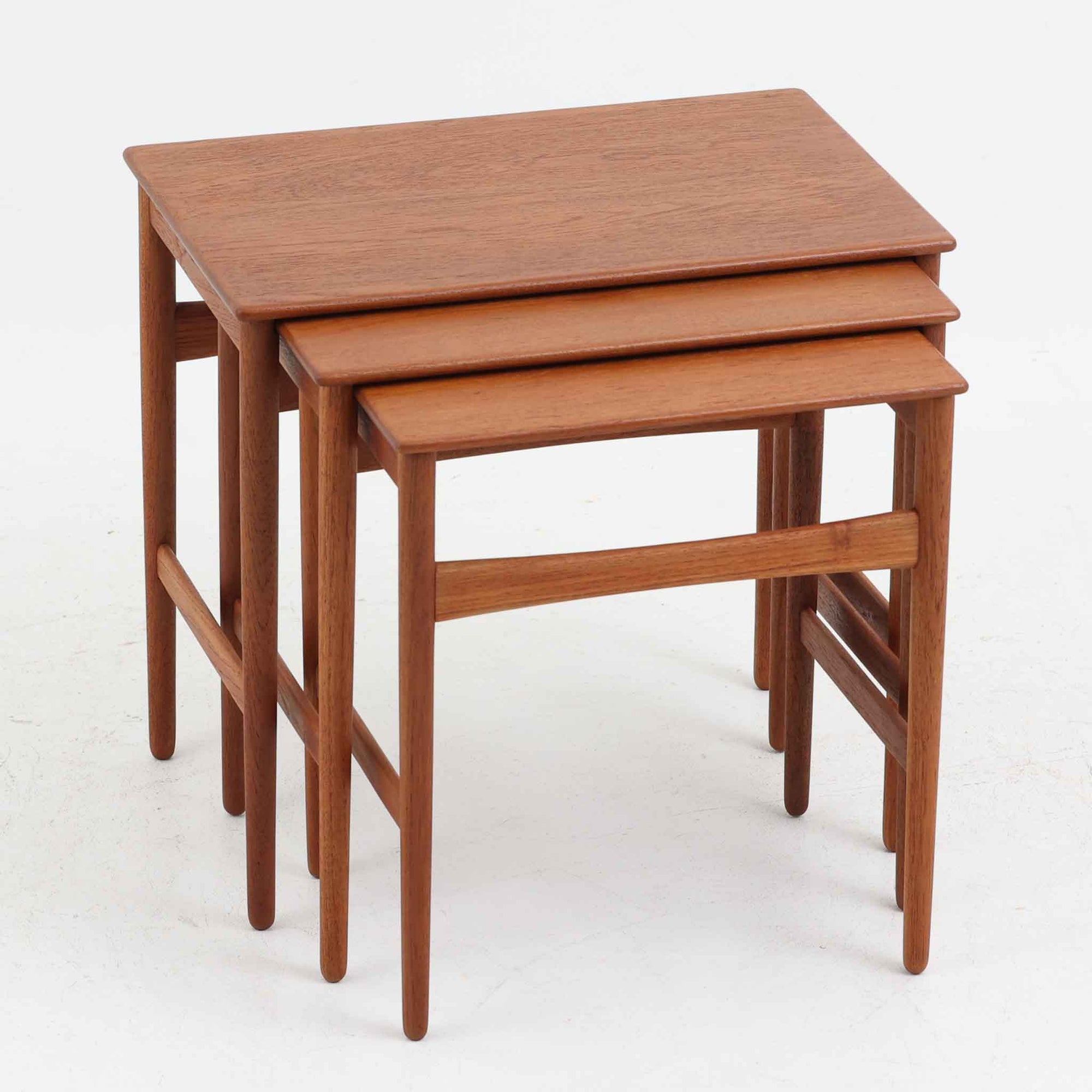 Hans J. Wegnerがデザインし、Andreas Tuck社より発表されたネストテーブル「AT40」です。チーク無垢材を贅沢に用いたシンプルで洗練されたフォルムは、使うほどに味わいを増し、経年変化による深みが楽しめます。大小3点が入れ子状に収まる構造で、省スペースでの収納性に優れながら必要な時にはサイドテーブルやティーテーブルとして自在に活躍します。細身の脚と滑らかな仕上げはウェグナーらしい職人技を感じさせ、日常に北欧デザインの機能美を取り入れられる逸品です。中でも本品はAT40の中でも全てがチーク無垢材で製作された希少なモデルであり、素材の質感を存分に堪能できる一点となっています。