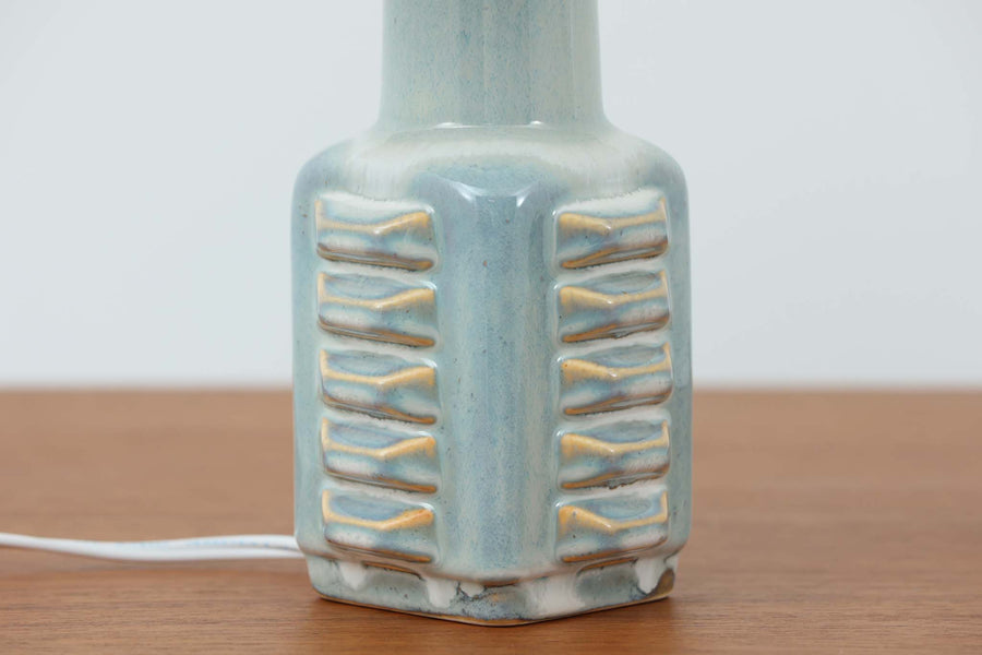デンマーク・ボーンホルム島の陶器メーカーSoholm（スーホルム）で製作されたテーブルランプ。デザイナーはEinar Johansen（アイナー・ヨハンセン）。立体的なレリーフ模様と、ブルーグレーに淡くアイスブルーが重なる美しい釉薬の表情が特徴です。ユニークなフォルムも印象的で、置くだけで空間に存在感をもたらします。シェードは新品のリネン製を合わせています。北欧ヴィンテージらしい温もりと洗練を兼ね備えた一点です。