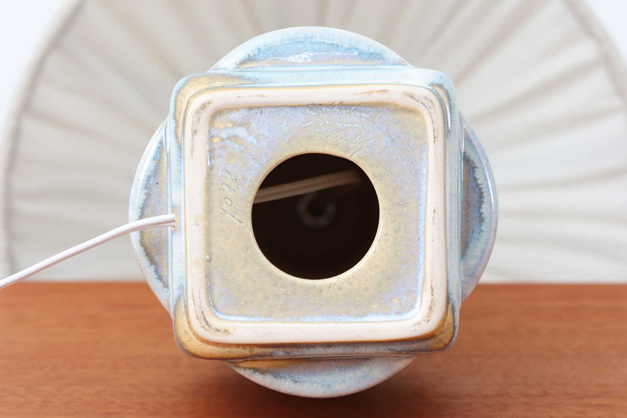 デンマーク・ボーンホルム島の陶器メーカー Soholm（スーホルム）で製作されたテーブルランプ。デザイナーは Einar Johansen（アイナー・ヨハンセン）。立体的なレリーフ模様と、ブルーグレーに淡くアイスブルーが重なる美しい釉薬の表情が特徴です。ユニークなフォルムも印象的で、置くだけで空間に存在感をもたらします。高さは約51cmとやや大きめで、サイドボードやコンソールの上などに置くと程よいボリューム感が生まれます。シェードは新品のリネン製を合わせています。北欧ヴィンテージらしい温もりと洗練を兼ね備えた一点です。