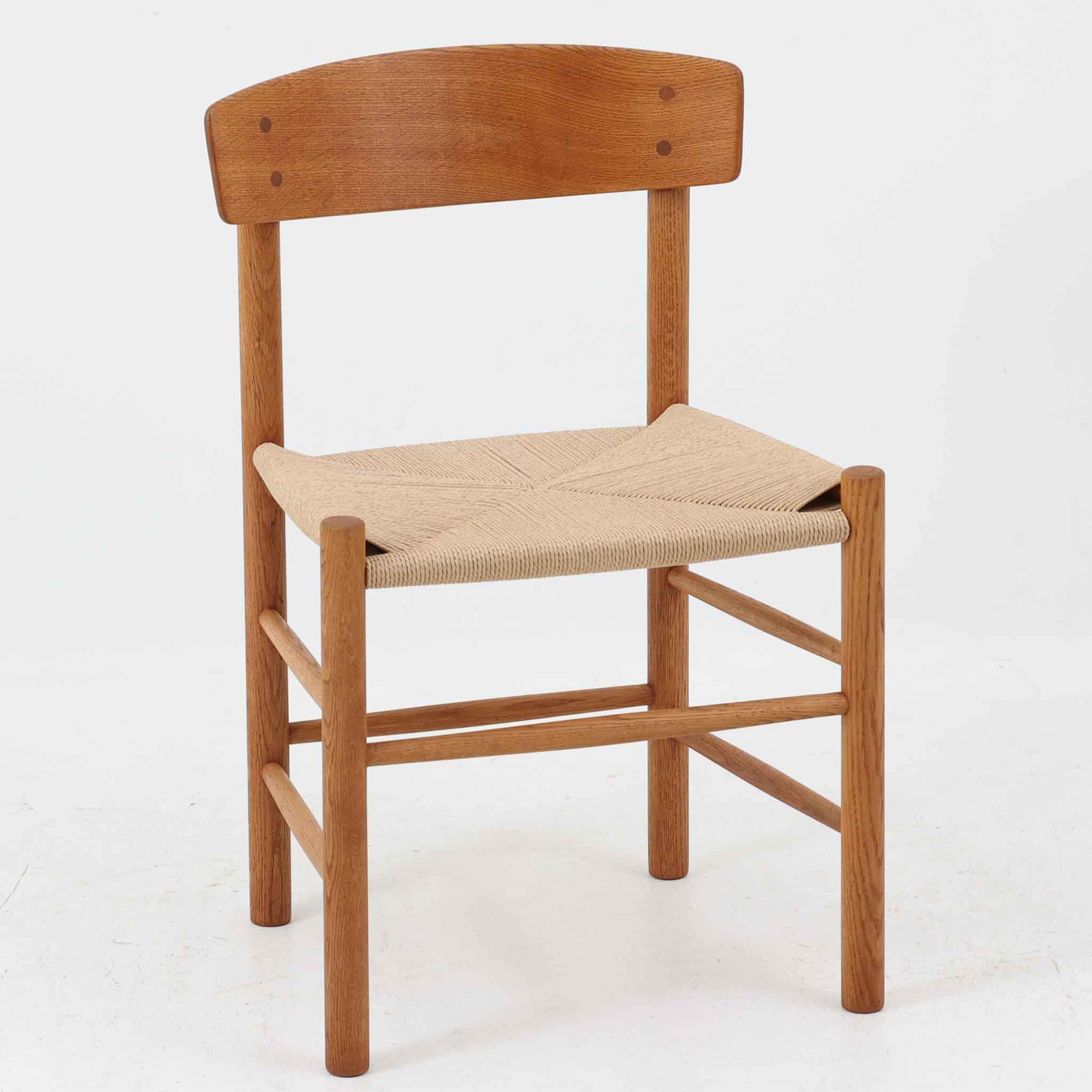 デンマークを代表するデザイナー、Borge MogensenによってFDBのためにデザインされたJ39チェアは、オーク材の丸脚と座面に丁寧に編み込まれたペーパーコードが特徴の、素朴ながらも完成度の高い北欧ビンテージチェアです。農村のキッチンチェアをルーツに持つそのデザインは、無駄を省いた潔い構造と機能美が融合し、空間に凛とした佇まいをもたらします。ダイニングはもちろん、ワークチェアやアクセントチェアとしても重宝する一脚です。