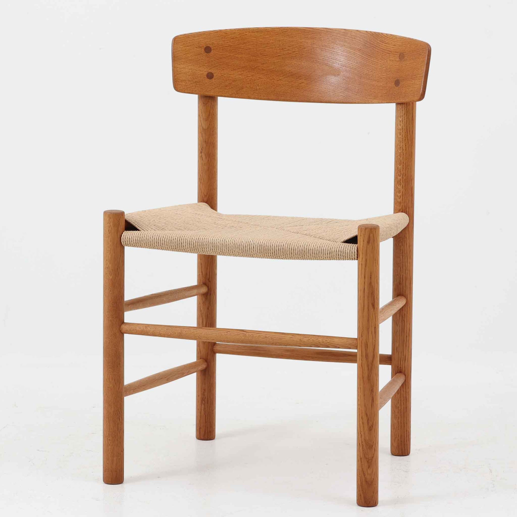 デンマークを代表するデザイナー、Borge MogensenによってFDBのためにデザインされたJ39チェアは、オーク材の丸脚と座面に丁寧に編み込まれたペーパーコードが特徴の、素朴ながらも完成度の高い北欧ビンテージチェアです。農村のキッチンチェアをルーツに持つそのデザインは、無駄を省いた潔い構造と機能美が融合し、空間に凛とした佇まいをもたらします。ダイニングはもちろん、ワークチェアやアクセントチェアとしても重宝する一脚です。