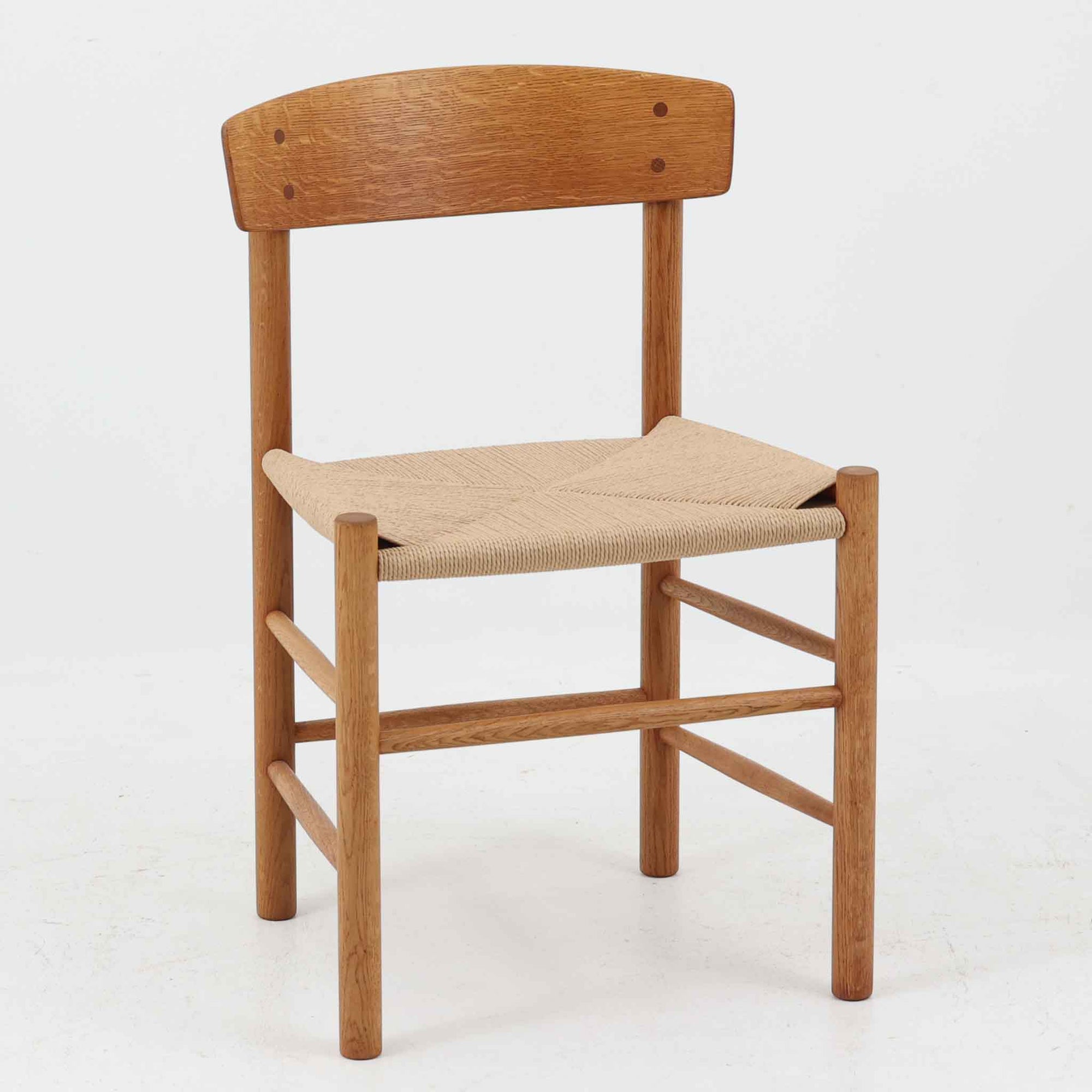 デンマークを代表するデザイナー、Borge MogensenによってFDBのためにデザインされたJ39チェアは、オーク材の丸脚と座面に丁寧に編み込まれたペーパーコードが特徴の、素朴ながらも完成度の高い北欧ビンテージチェアです。農村のキッチンチェアをルーツに持つそのデザインは、無駄を省いた潔い構造と機能美が融合し、空間に凛とした佇まいをもたらします。ダイニングはもちろん、ワークチェアやアクセントチェアとしても重宝する一脚です。