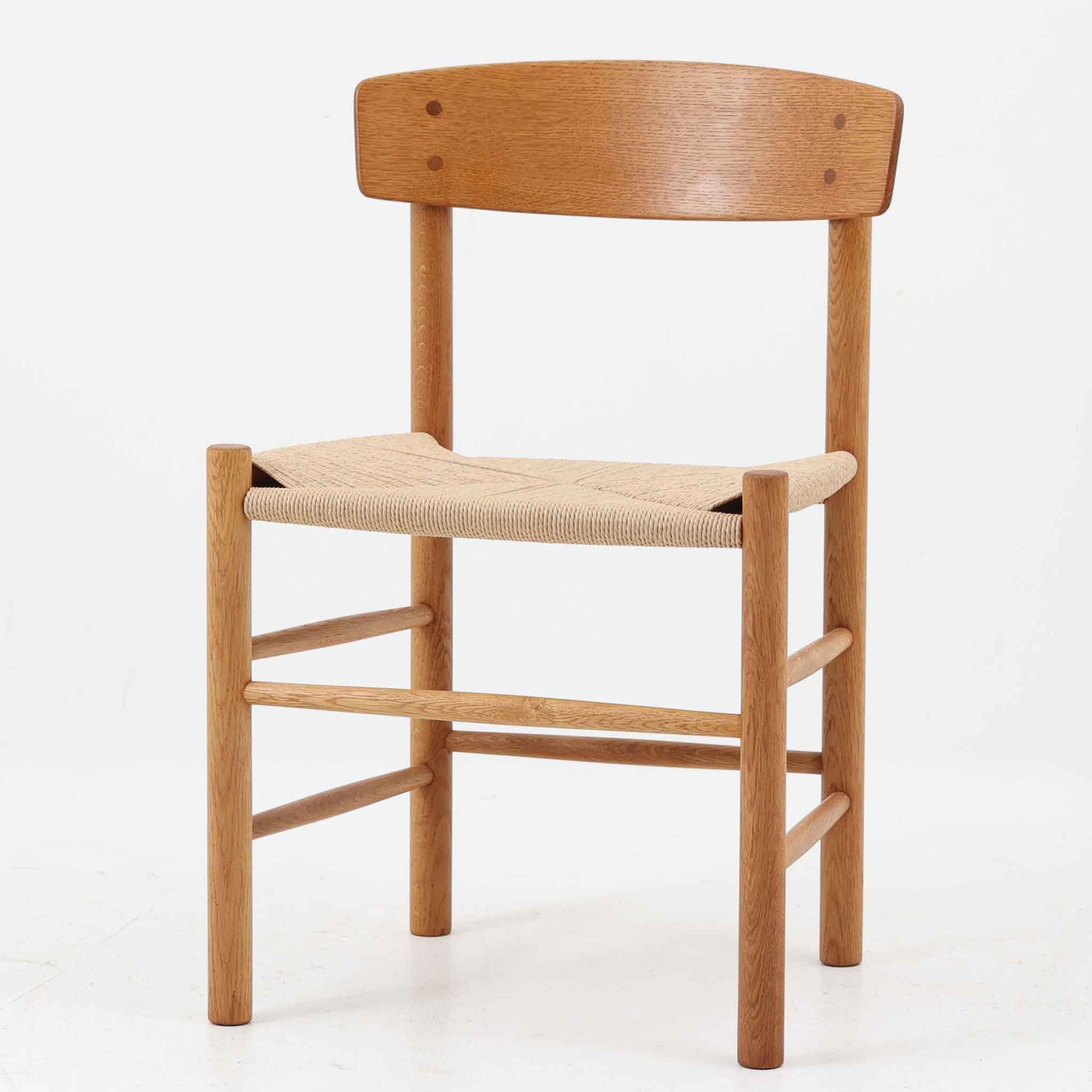 デンマークを代表するデザイナー、Borge MogensenによってFDBのためにデザインされたJ39チェアは、オーク材の丸脚と座面に丁寧に編み込まれたペーパーコードが特徴の、素朴ながらも完成度の高い北欧ビンテージチェアです。農村のキッチンチェアをルーツに持つそのデザインは、無駄を省いた潔い構造と機能美が融合し、空間に凛とした佇まいをもたらします。ダイニングはもちろん、ワークチェアやアクセントチェアとしても重宝する一脚です。