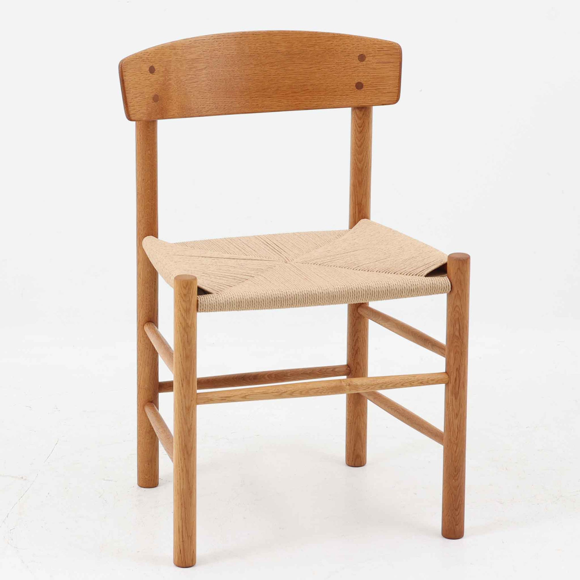 デンマークを代表するデザイナー、Borge MogensenによってFDBのためにデザインされたJ39チェアは、オーク材の丸脚と座面に丁寧に編み込まれたペーパーコードが特徴の、素朴ながらも完成度の高い北欧ビンテージチェアです。農村のキッチンチェアをルーツに持つそのデザインは、無駄を省いた潔い構造と機能美が融合し、空間に凛とした佇まいをもたらします。ダイニングはもちろん、ワークチェアやアクセントチェアとしても重宝する一脚です。