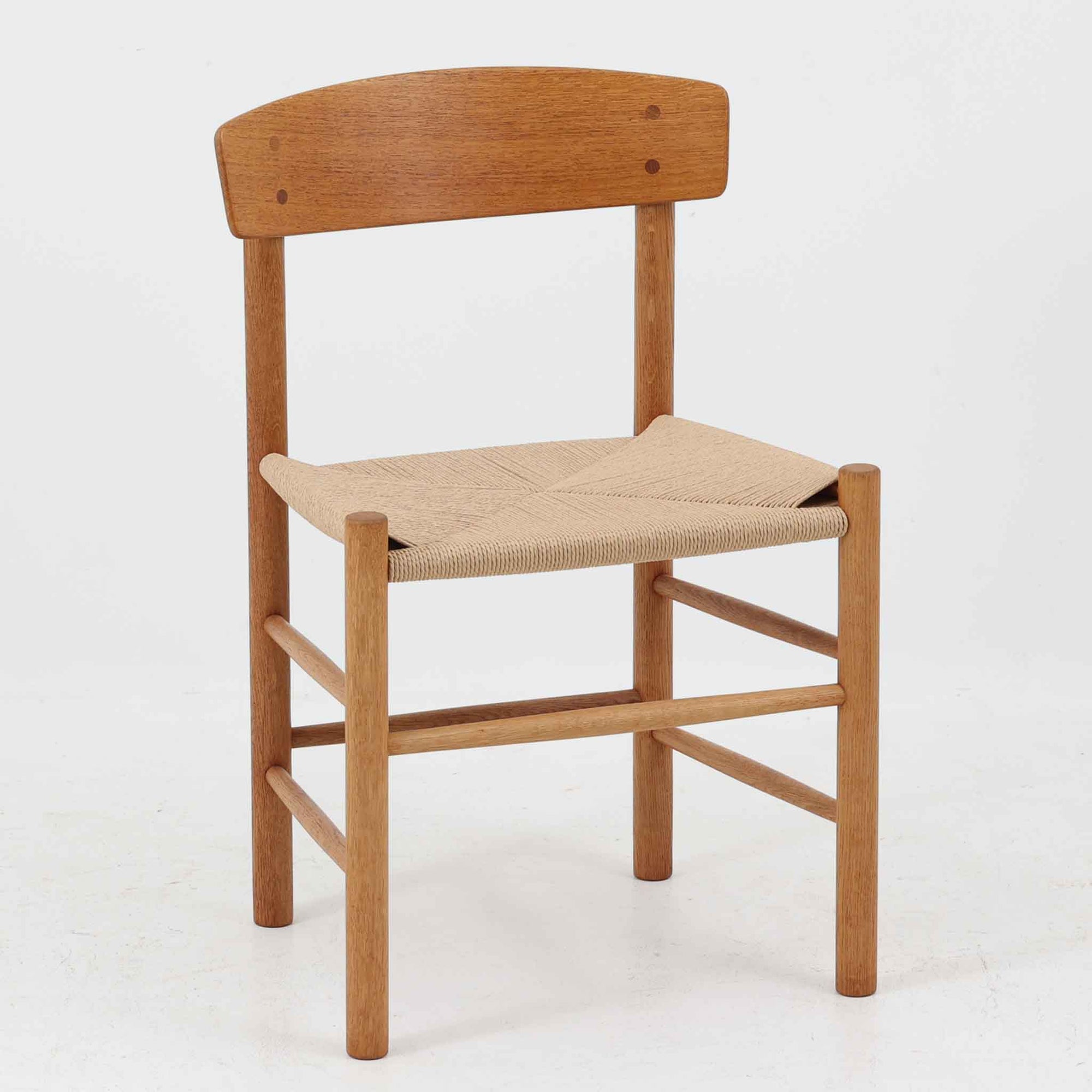 デンマークを代表するデザイナー、Borge MogensenによってFDBのためにデザインされたJ39チェアは、オーク材の丸脚と座面に丁寧に編み込まれたペーパーコードが特徴の、素朴ながらも完成度の高い北欧ビンテージチェアです。農村のキッチンチェアをルーツに持つそのデザインは、無駄を省いた潔い構造と機能美が融合し、空間に凛とした佇まいをもたらします。ダイニングはもちろん、ワークチェアやアクセントチェアとしても重宝する一脚です。