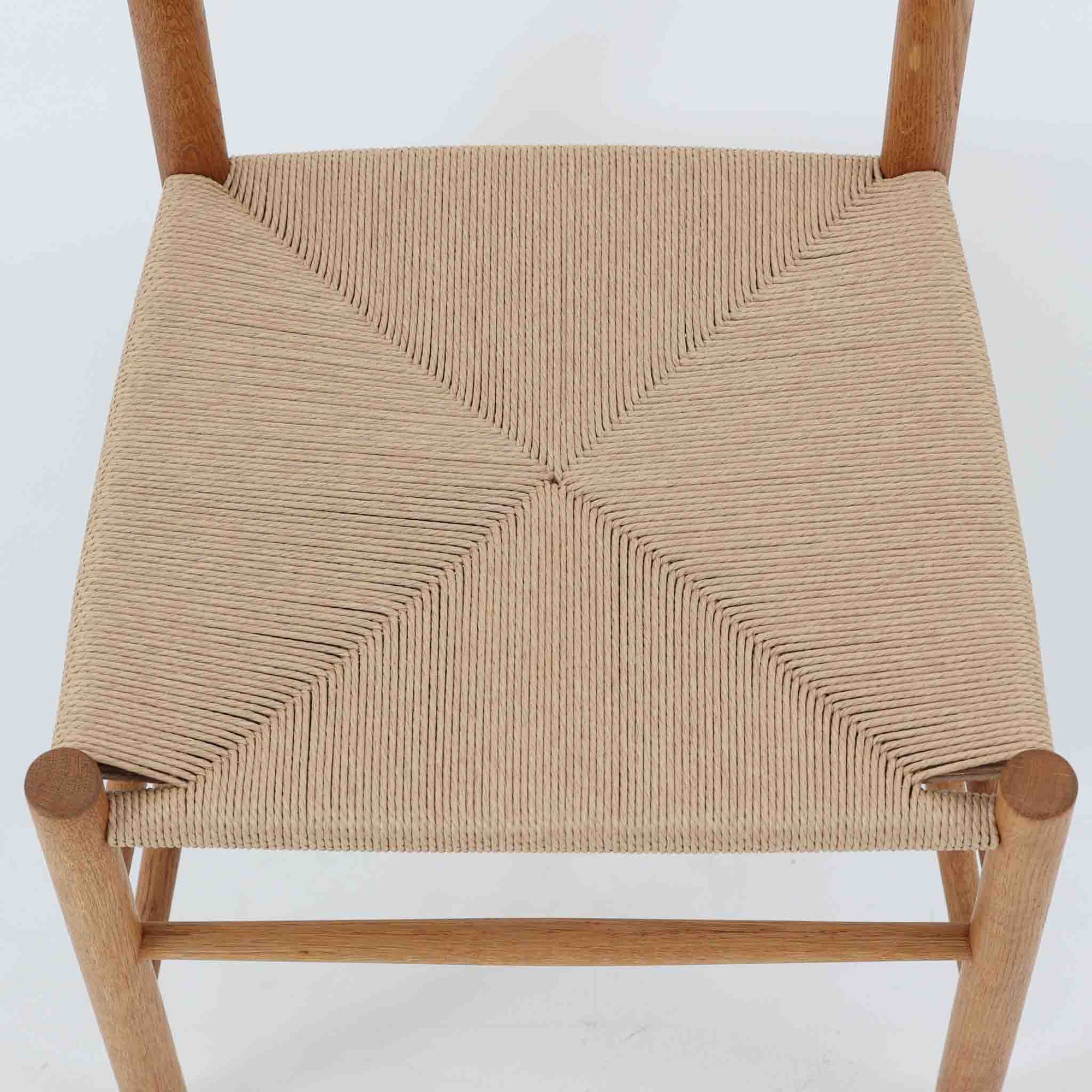 デンマークを代表するデザイナー、Borge MogensenによってFDBのためにデザインされたJ39チェアは、オーク材の丸脚と座面に丁寧に編み込まれたペーパーコードが特徴の、素朴ながらも完成度の高い北欧ビンテージチェアです。農村のキッチンチェアをルーツに持つそのデザインは、無駄を省いた潔い構造と機能美が融合し、空間に凛とした佇まいをもたらします。ダイニングはもちろん、ワークチェアやアクセントチェアとしても重宝する一脚です。