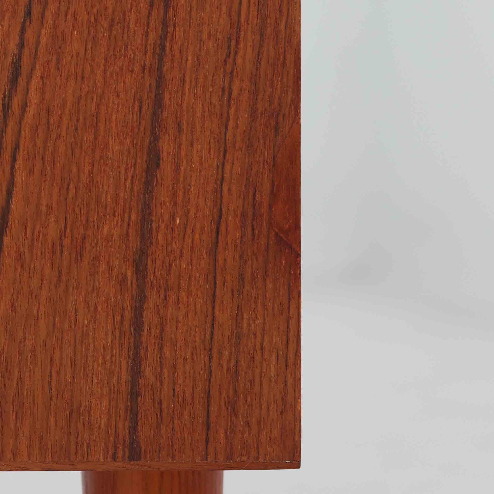 デンマーク製の収納キャビネットです。上段には観音開きの扉内に可動棚が設けられており、食器や書類をすっきりと整理できます。内部まで丁寧に仕上げられており、扉を開けてお気に入りの器やオブジェを飾る“見せる収納”としても楽しめます。扉には鍵が付属しており、大切なものを安全に保管することも可能です。下段には2杯の引き出しが備わり、小物類や日用品の収納にも便利。チーク材の豊かな木目と深みのある色合いが美しく、北欧家具らしい温もりを感じさせます。脚部のテーパー形状が全体を軽やかに見せ、シンプルながら上質な存在感を放つ一台です。