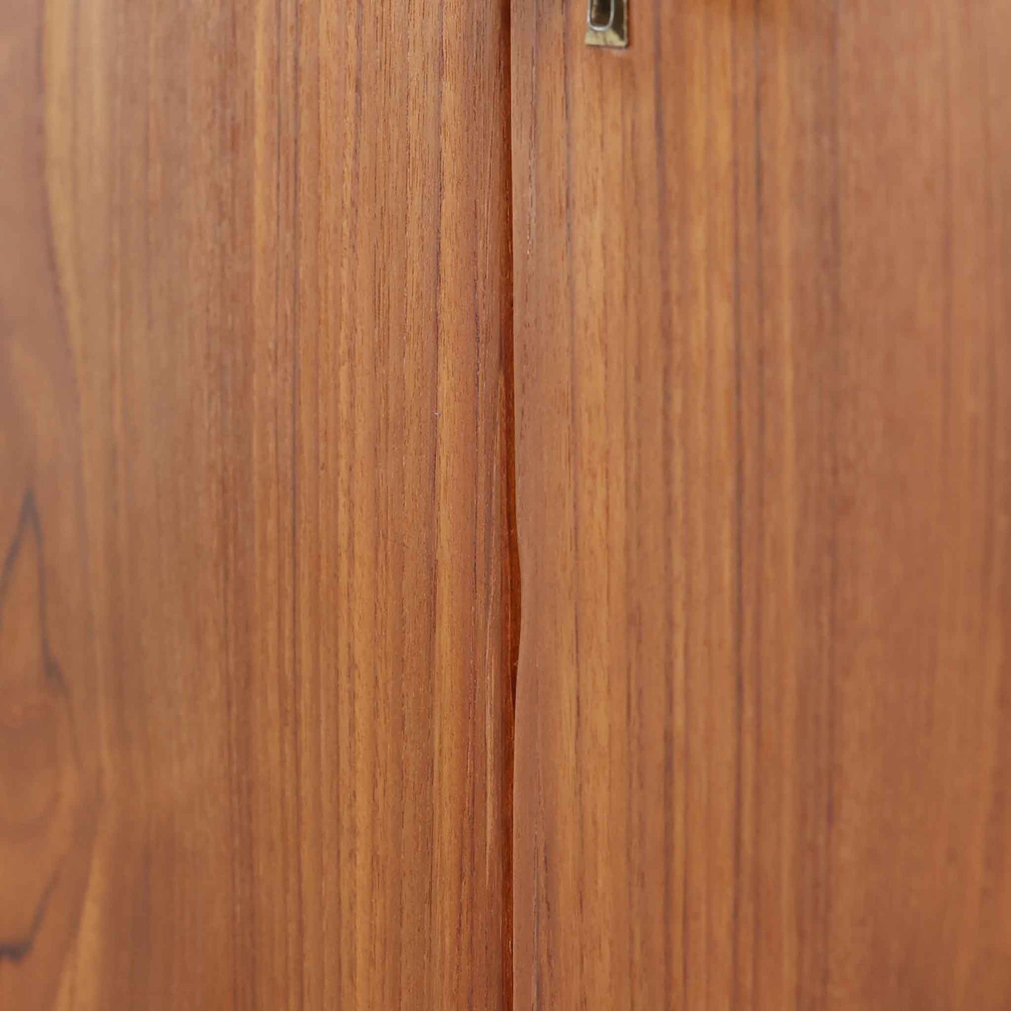 デンマーク製の収納キャビネットです。上段には観音開きの扉内に可動棚が設けられており、食器や書類をすっきりと整理できます。内部まで丁寧に仕上げられており、扉を開けてお気に入りの器やオブジェを飾る“見せる収納”としても楽しめます。扉には鍵が付属しており、大切なものを安全に保管することも可能です。下段には2杯の引き出しが備わり、小物類や日用品の収納にも便利。チーク材の豊かな木目と深みのある色合いが美しく、北欧家具らしい温もりを感じさせます。脚部のテーパー形状が全体を軽やかに見せ、シンプルながら上質な存在感を放つ一台です。