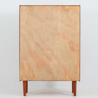 デンマーク製の収納キャビネットです。上段には観音開きの扉内に可動棚が設けられており、食器や書類をすっきりと整理できます。内部まで丁寧に仕上げられており、扉を開けてお気に入りの器やオブジェを飾る“見せる収納”としても楽しめます。扉には鍵が付属しており、大切なものを安全に保管することも可能です。下段には2杯の引き出しが備わり、小物類や日用品の収納にも便利。チーク材の豊かな木目と深みのある色合いが美しく、北欧家具らしい温もりを感じさせます。脚部のテーパー形状が全体を軽やかに見せ、シンプルながら上質な存在感を放つ一台です。