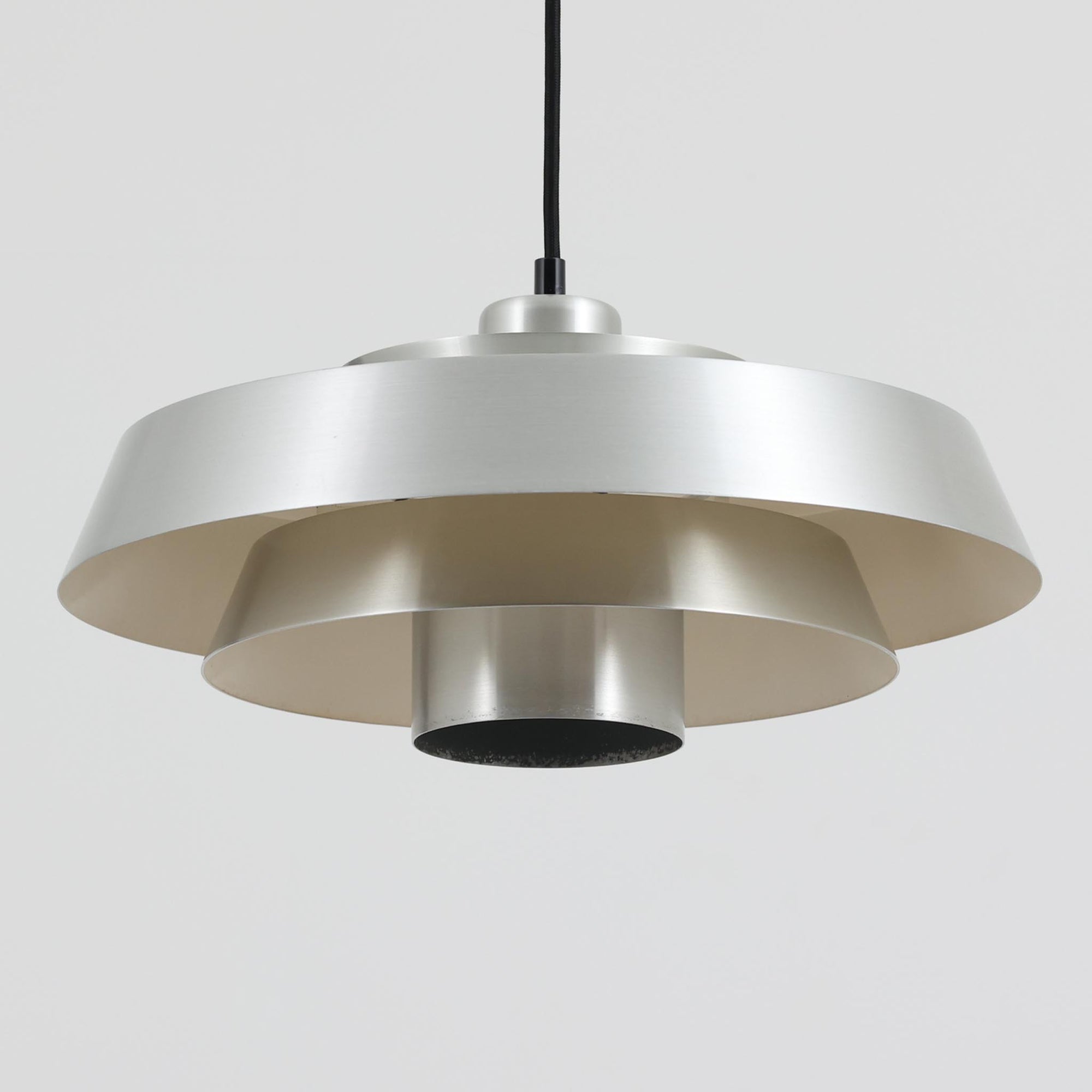 Jo Hammerborgがデザインし、Fog &amp; Morup社から発表されたペンダントライト「Nova」です。アルミを用いた精緻なシェード構造が特徴で、直径40cmのサイズはダイニングやリビングの照明に適しています。重なり合うシェードが光を柔らかく拡散し、眩しさを抑えながら温かみのある空間を演出。シルバーの質感と洗練されたフォルムは、モダンでありながら北欧デザインらしい静かな存在感を放ちます。ビンテージならではの希少性に加え、素材の経年変化が加わることで、光とともに独特の風合いを楽しめる逸品です。