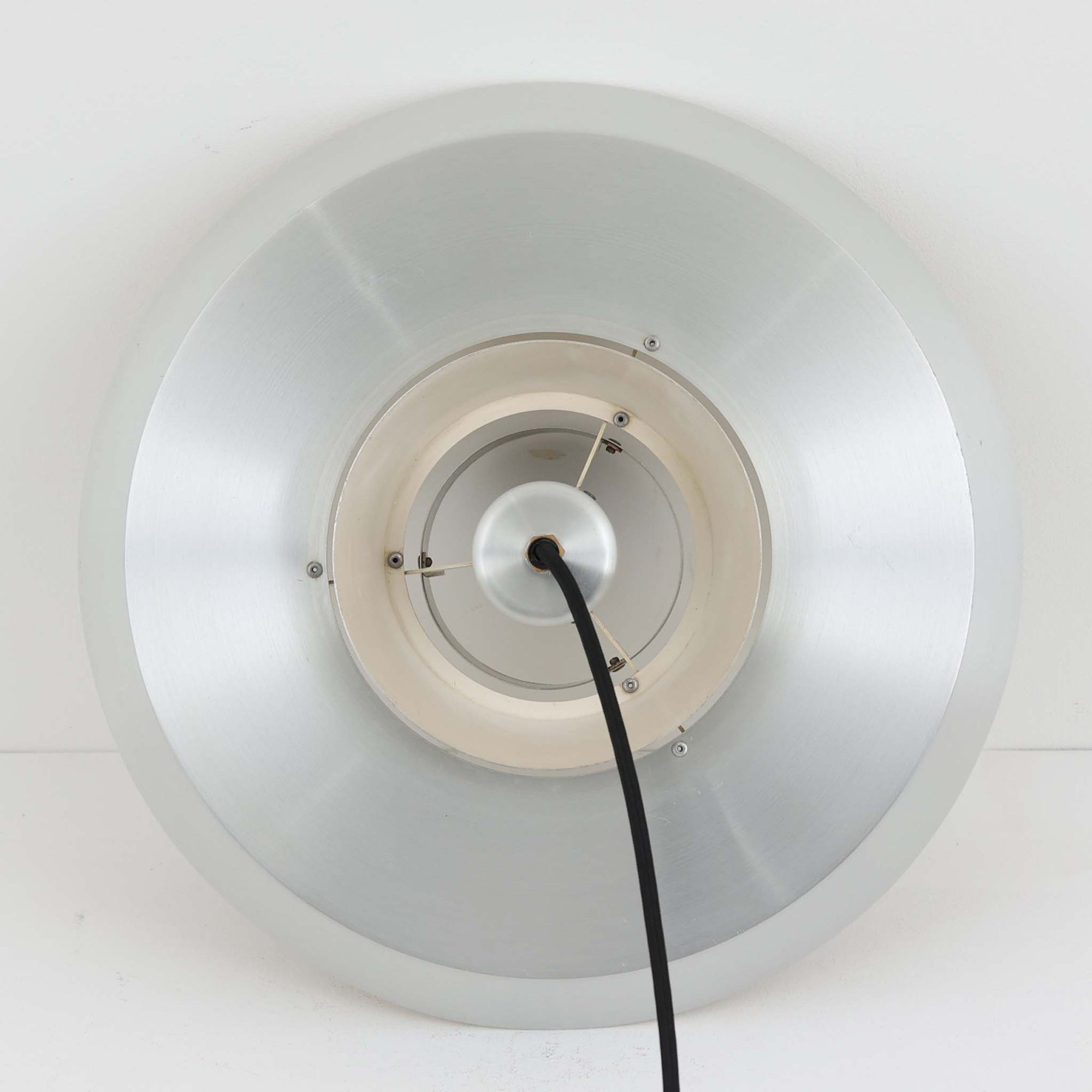 Jo Hammerborgがデザインし、Fog &amp; Morup社から発表されたペンダントライト「Nova」です。アルミを用いた精緻なシェード構造が特徴で、直径40cmのサイズはダイニングやリビングの照明に適しています。重なり合うシェードが光を柔らかく拡散し、眩しさを抑えながら温かみのある空間を演出。シルバーの質感と洗練されたフォルムは、モダンでありながら北欧デザインらしい静かな存在感を放ちます。ビンテージならではの希少性に加え、素材の経年変化が加わることで、光とともに独特の風合いを楽しめる逸品です。