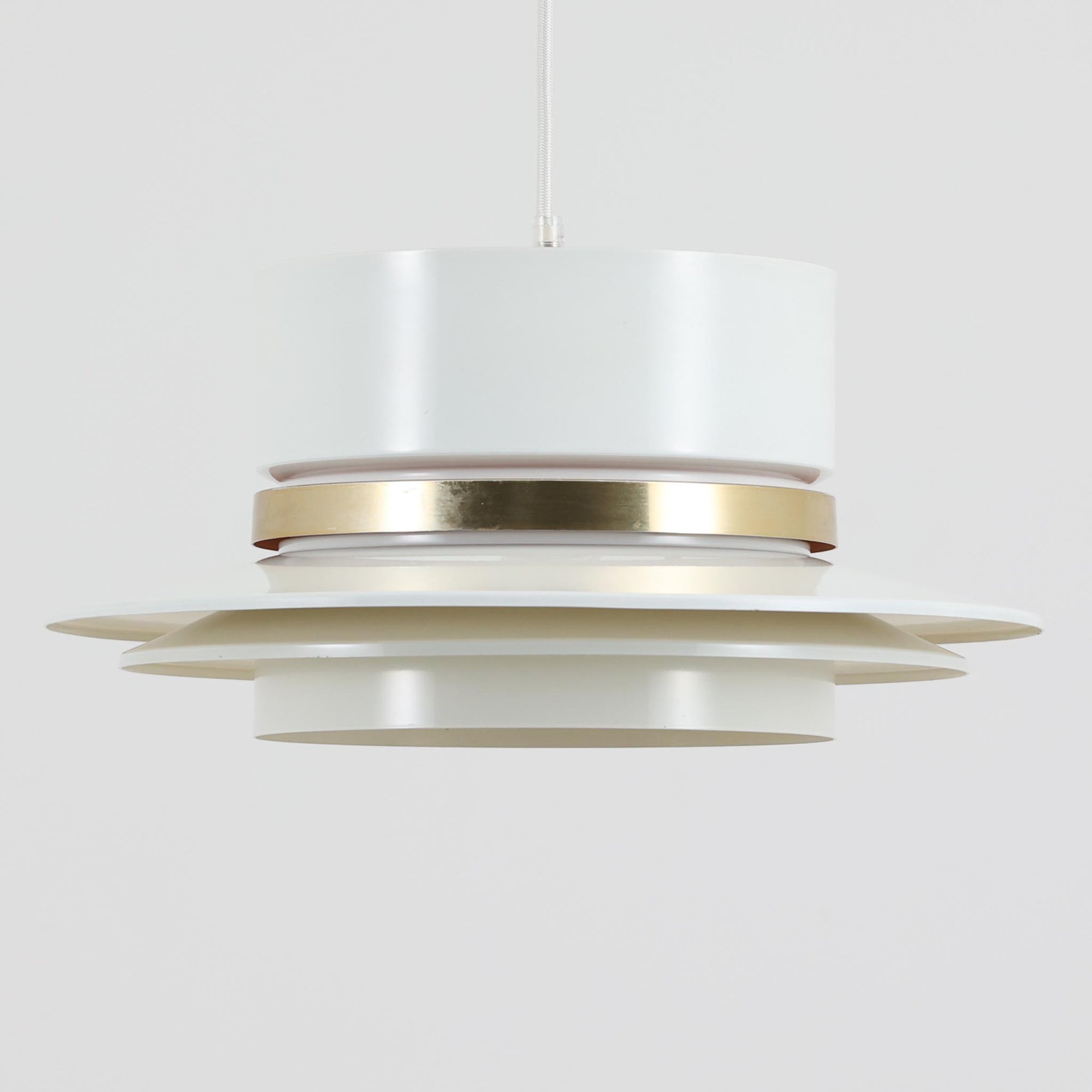 Carl Thoreが手掛けたGranhaga社製のペンダントライトです。直径41cmの存在感あるサイズで、複数のアルミ製シェードを重ねた構造により、光が柔らかく拡散しながらも独特の陰影を生み出します。中央に配された真鍮色のアクセントが上品さを引き立て、点灯時には温かな光が空間を心地よく包み込みます。ダイニングやリビングのメイン照明としてはもちろん、ビンテージならではの希少性と美しいデザインがインテリアの主役となる一品です。