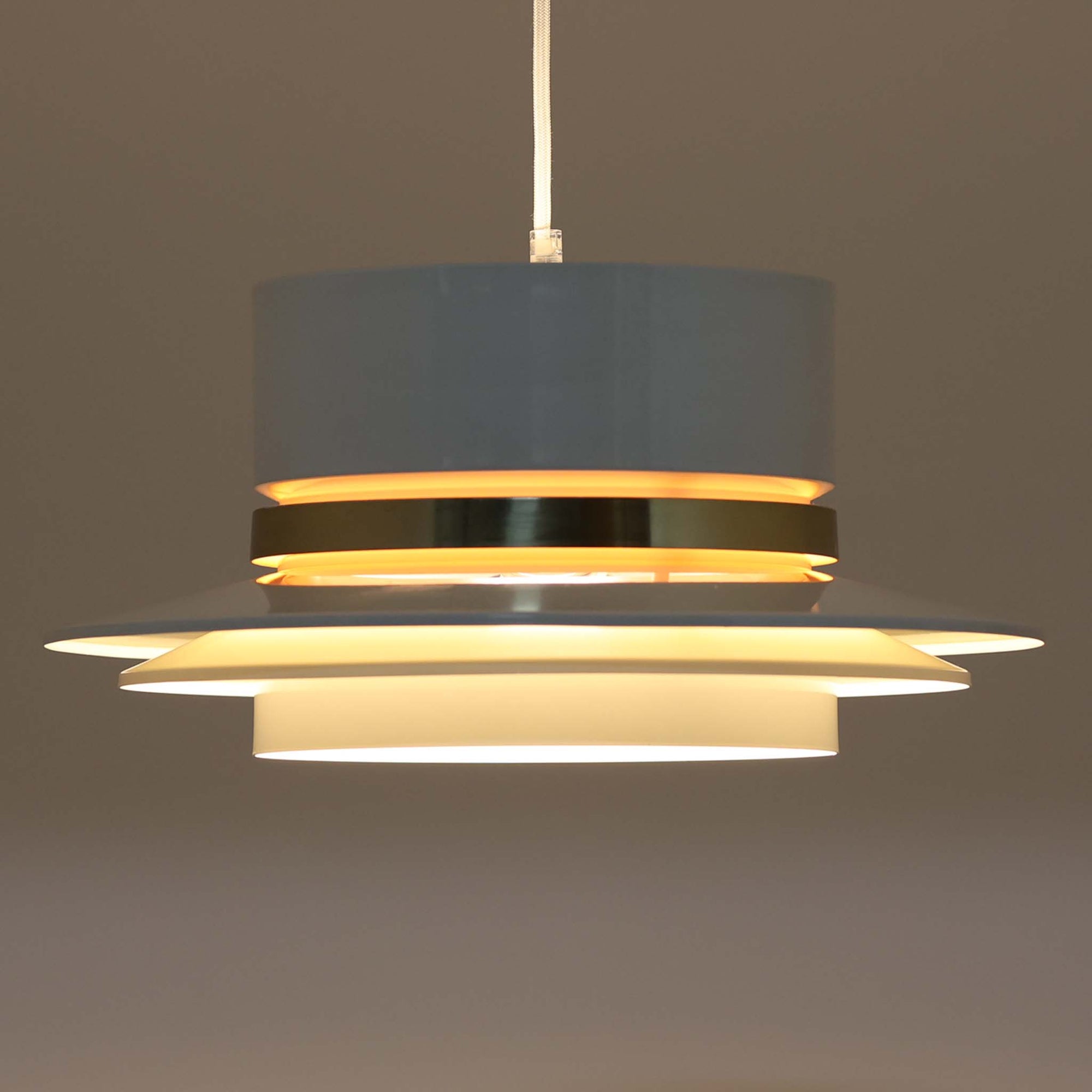 Carl Thoreが手掛けたGranhaga社製のペンダントライトです。直径41cmの存在感あるサイズで、複数のアルミ製シェードを重ねた構造により、光が柔らかく拡散しながらも独特の陰影を生み出します。中央に配された真鍮色のアクセントが上品さを引き立て、点灯時には温かな光が空間を心地よく包み込みます。ダイニングやリビングのメイン照明としてはもちろん、ビンテージならではの希少性と美しいデザインがインテリアの主役となる一品です。