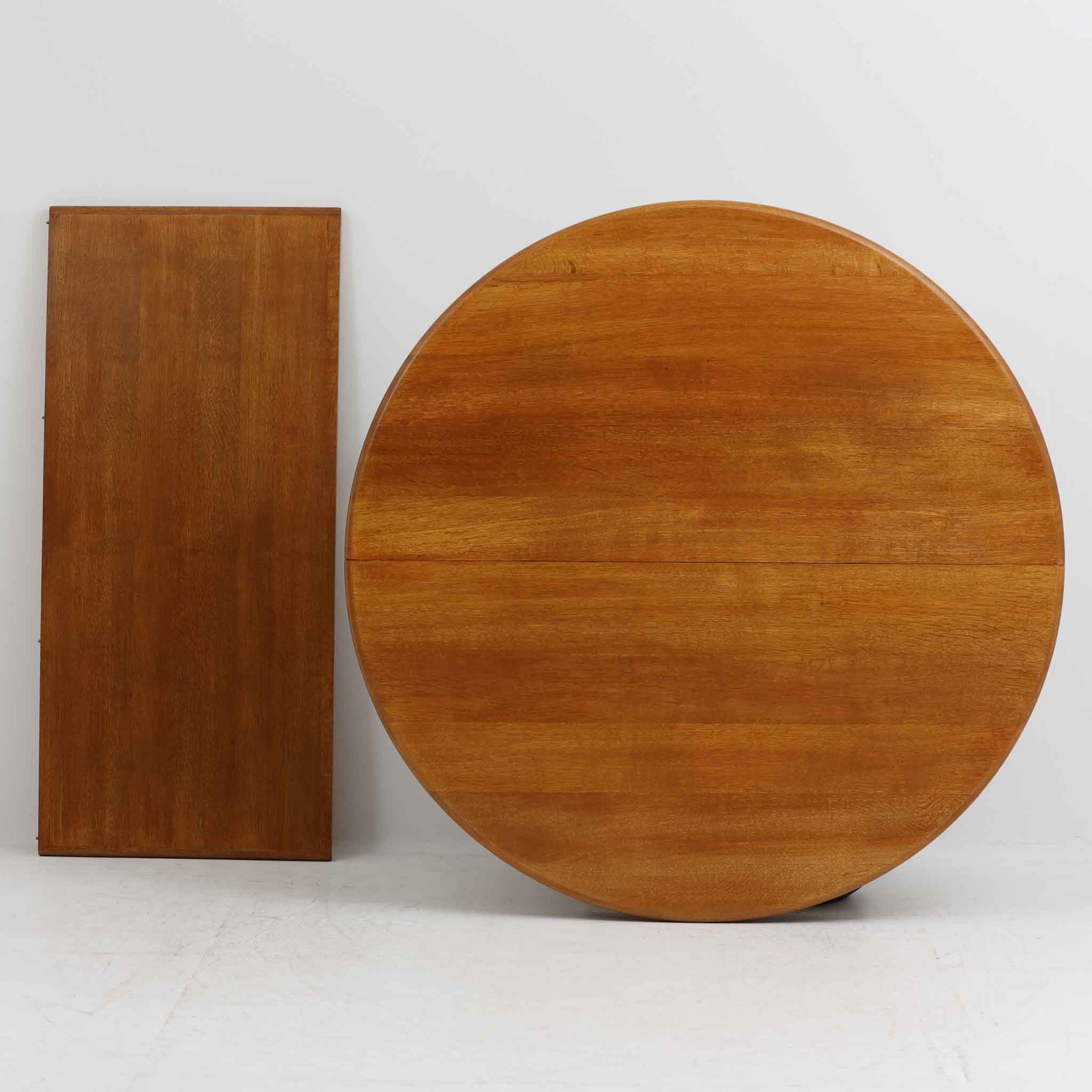 デンマーク製の円形エクステンションダイニングテーブルです。天板には贅沢にオーク無垢材が使用され、木の温もりとしっかりとした造りが魅力。拡張板にはオーク突板が用いられており、ラウンド形状からオーバル形状へと変化する機能的な構造が特徴です。経年により深みを増した木肌が味わい深く、北欧ビンテージならではの温かみのある雰囲気を演出します。普段の食卓としてはもちろん、来客時にも活躍する実用性と美しさを兼ね備えた一台です。