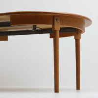 デンマーク製の円形エクステンションダイニングテーブルです。天板には贅沢にオーク無垢材が使用され、木の温もりとしっかりとした造りが魅力。拡張板にはオーク突板が用いられており、ラウンド形状からオーバル形状へと変化する機能的な構造が特徴です。経年により深みを増した木肌が味わい深く、北欧ビンテージならではの温かみのある雰囲気を演出します。普段の食卓としてはもちろん、来客時にも活躍する実用性と美しさを兼ね備えた一台です。