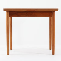 素材と構造の完成度の高さが際立つ正方形エクステンションダイニングテーブルです。天板には上質なチーク材が用いられ、木目の美しさと経年変化による深みのある色合いが北欧ビンテージらしい佇まいを演出します。普段はコンパクトな正方形として使用でき、来客時には左右の天板を引き出すことで広々としたサイズへと拡張可能な実用的な構造です。細身の脚部と幕板のバランスも良く、空間に軽やかな印象を与えます。