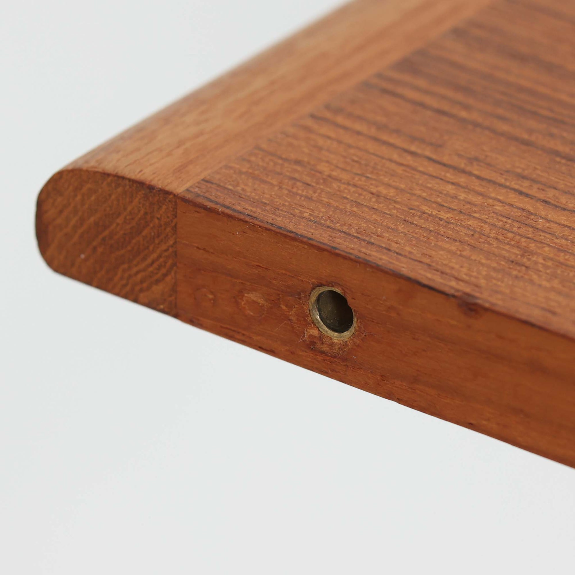 デンマーク製の北欧ビンテージ円形ダイニングテーブルです。チーク材の美しい木目が天板いっぱいに広がり、縁に施されたなだらかな丸みがやわらかな印象を与えます。幅110cmから165cm、さらに220cmまで拡張可能なエクステンション構造で、来客時にもゆとりあるレイアウトを実現。幕板から脚部へとつながる端正なフォルムは職人の確かな技術を感じさせます。家族の団らんからホームパーティーまで幅広く活躍し、経年により深みを増した色艶が空間に温もりと存在感をもたらす一台です。