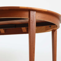 デンマーク製の北欧ビンテージ円形ダイニングテーブルです。チーク材の美しい木目が天板いっぱいに広がり、縁に施されたなだらかな丸みがやわらかな印象を与えます。幅110cmから165cm、さらに220cmまで拡張可能なエクステンション構造で、来客時にもゆとりあるレイアウトを実現。幕板から脚部へとつながる端正なフォルムは職人の確かな技術を感じさせます。家族の団らんからホームパーティーまで幅広く活躍し、経年により深みを増した色艶が空間に温もりと存在感をもたらす一台です。